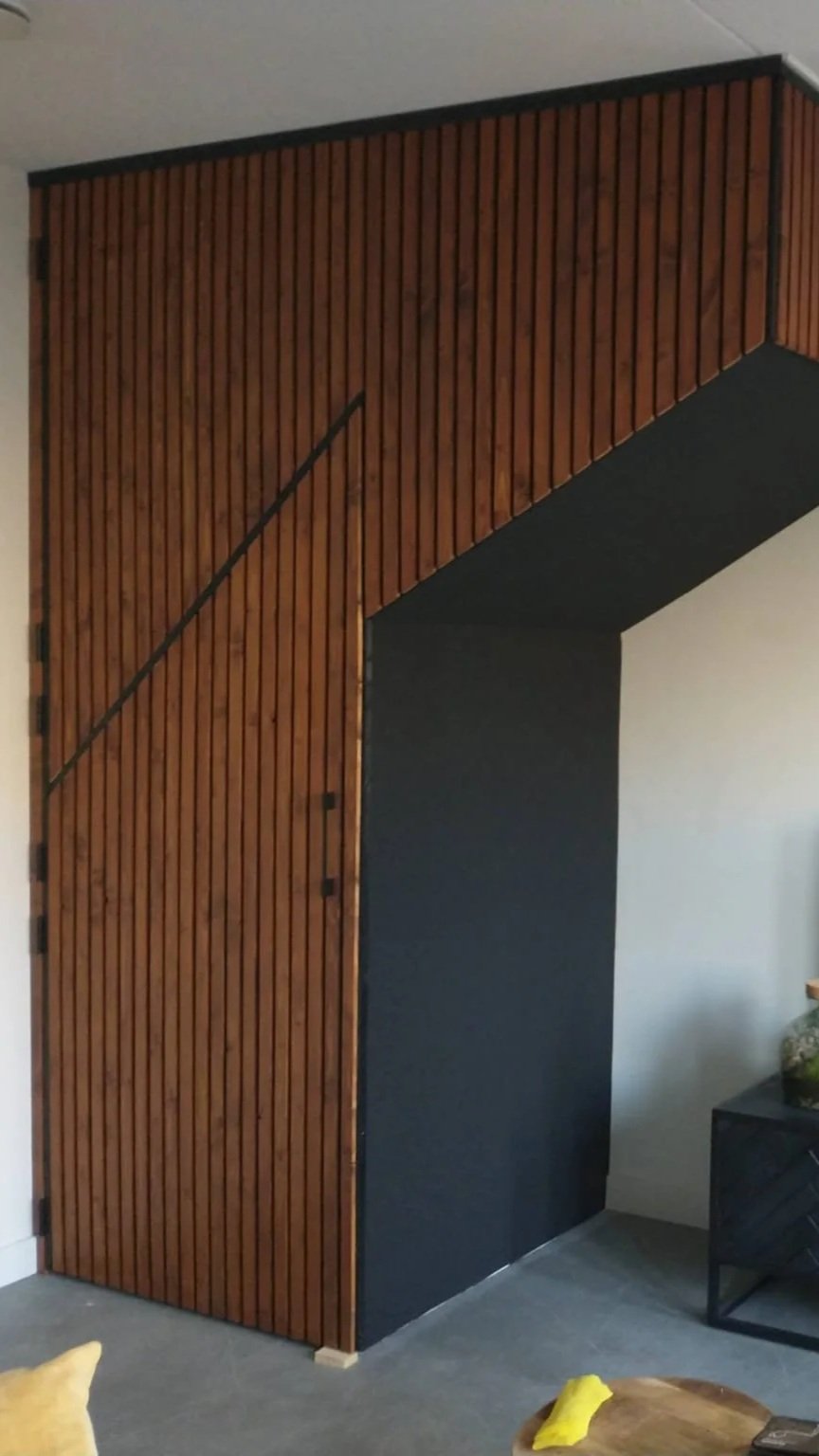 Houten trapkast met verticale latten op een zwarte achtergrond. Interieurfoto