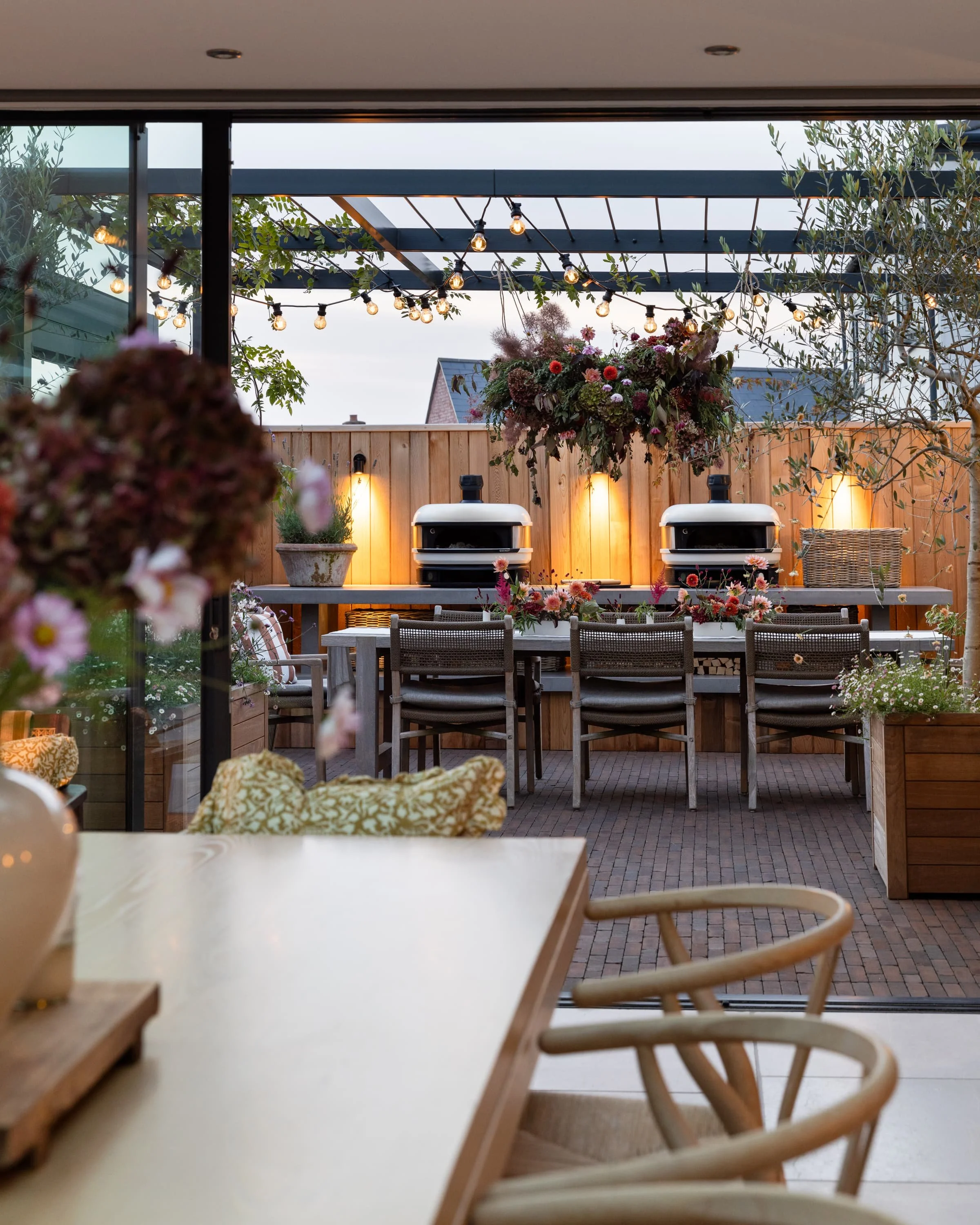 Open-canopy outdoor kitchen with pizza ovens for casual dining and entertaining