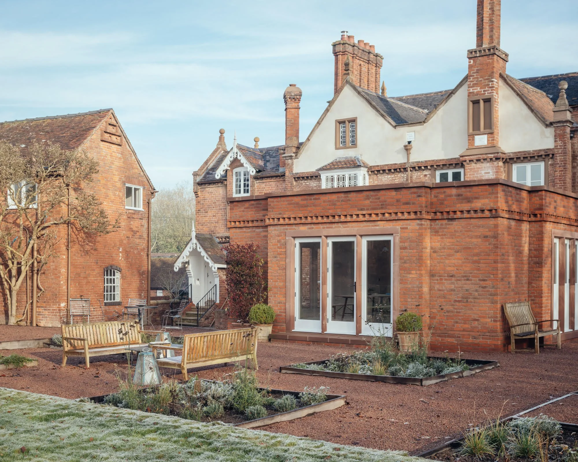 Historic estate garden with symmetry, mature trees, and planting inspired by traditional manor grounds