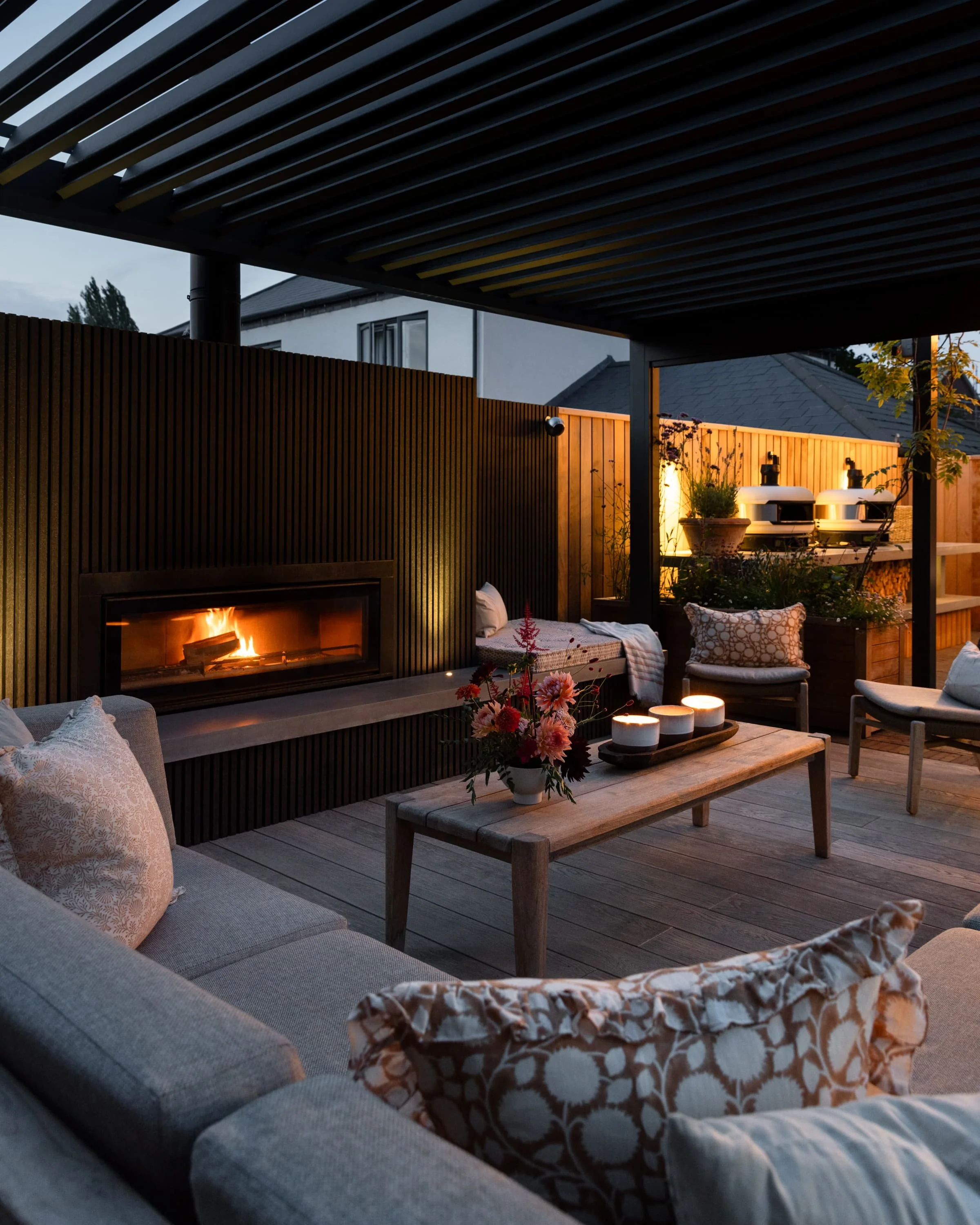 Strategically placed garden lights accentuating pathways, fireplace, and planting at night