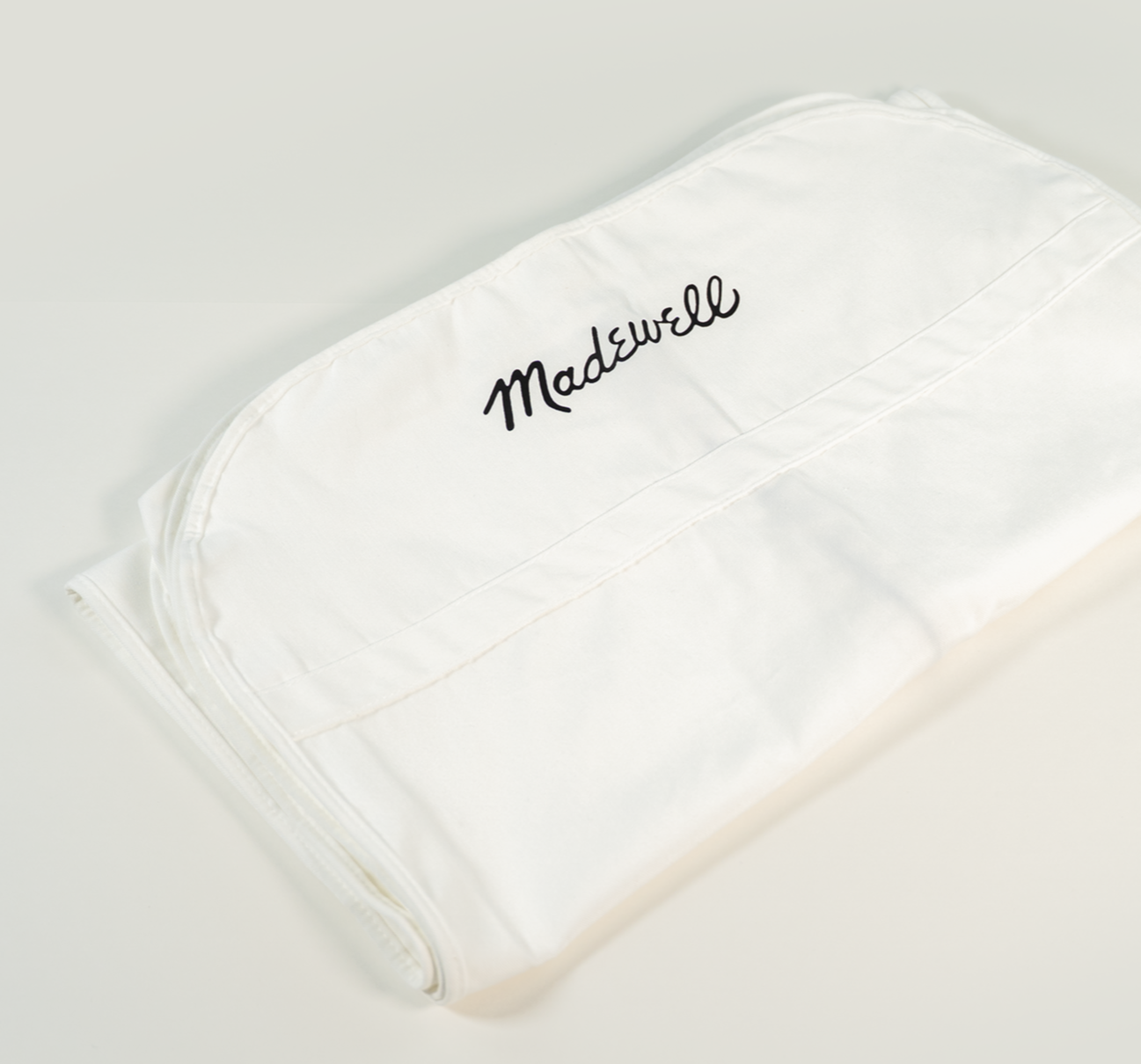 A green box with a drawstring bag inside featuring a swan logo.