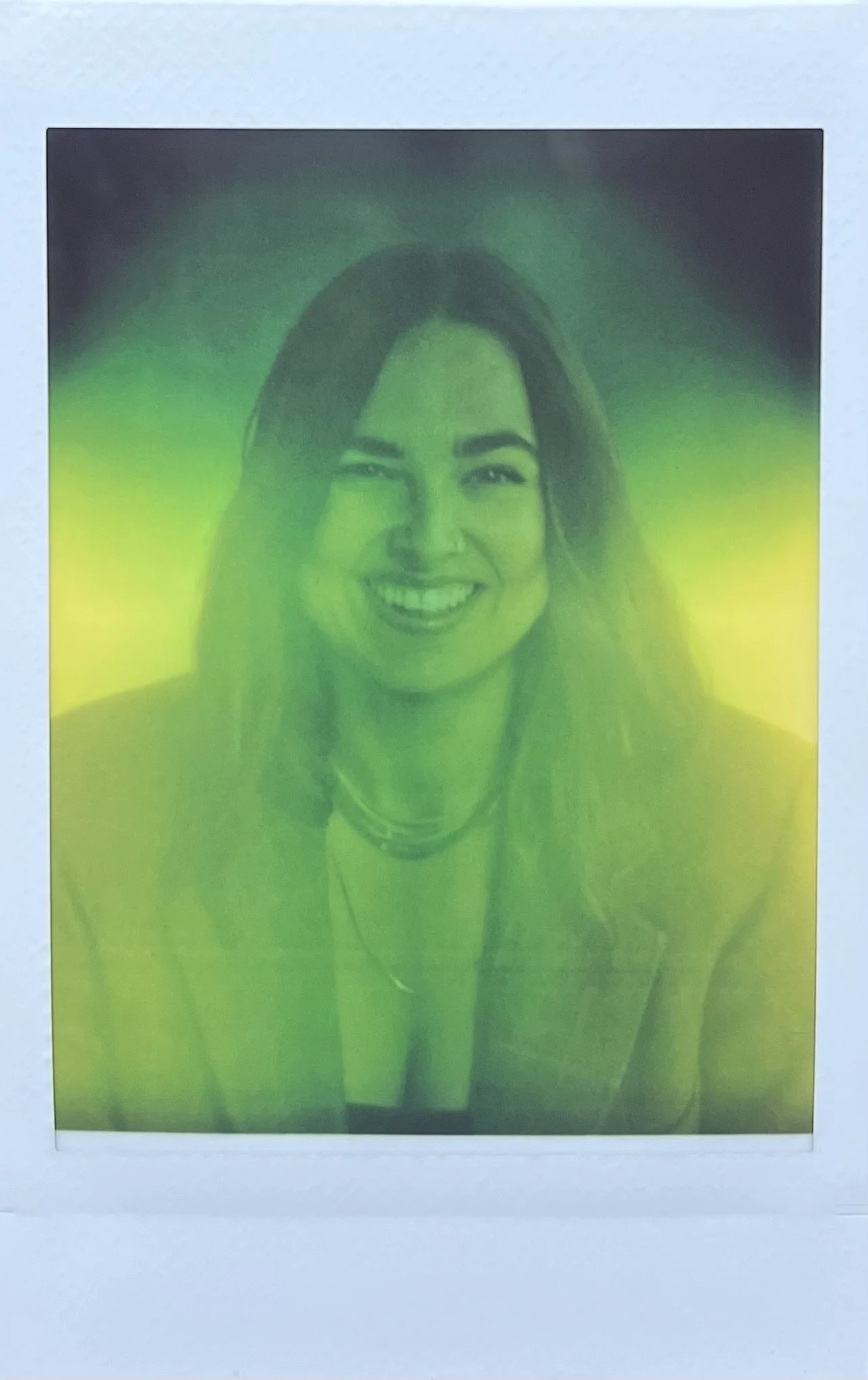 Ein Porträt einer lachenden Frau, das durch grünliche Farbverlaufsfilter bearbeitet wurde.