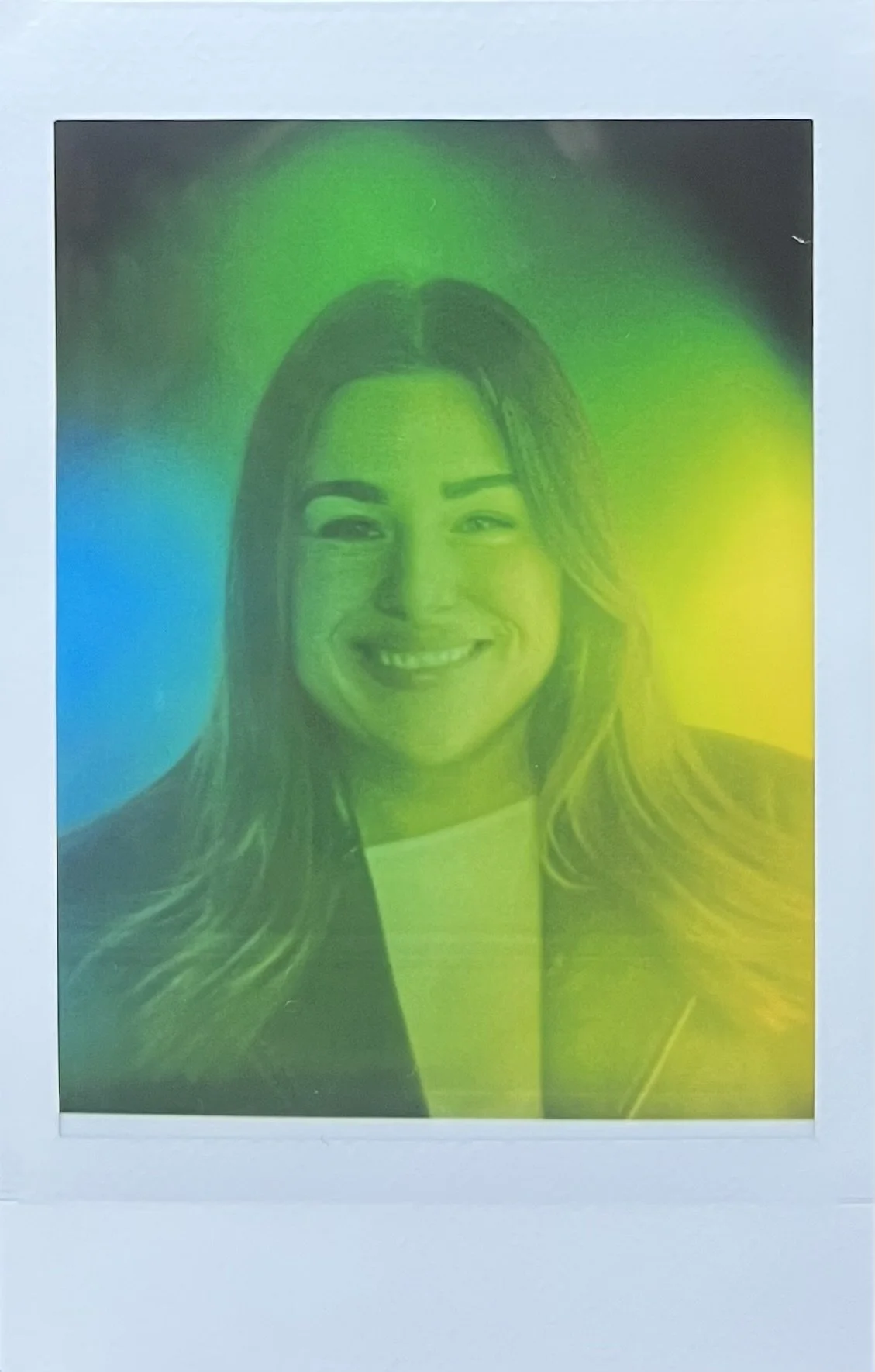 Schwarz-Weiß-Porträt einer lachenden Frau mit langem Haar, überlagert von buntem Farbfilter in Blau, Grün, Gelb und Neonfarben.