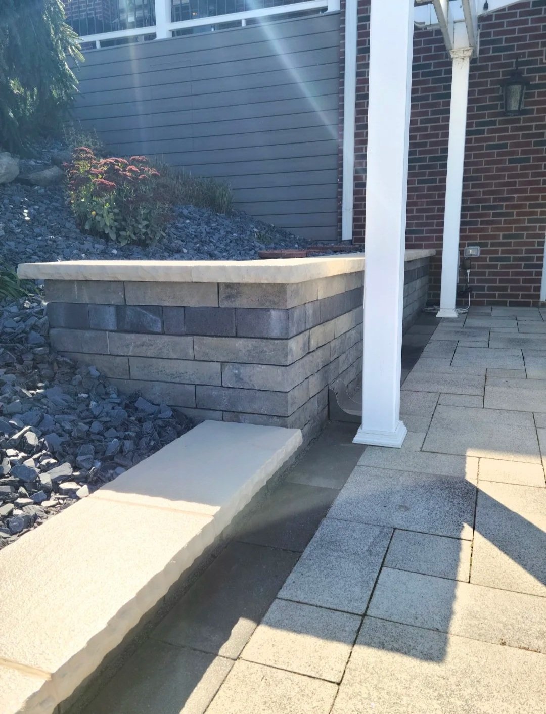 Paver patio with a pergola and retaining wall