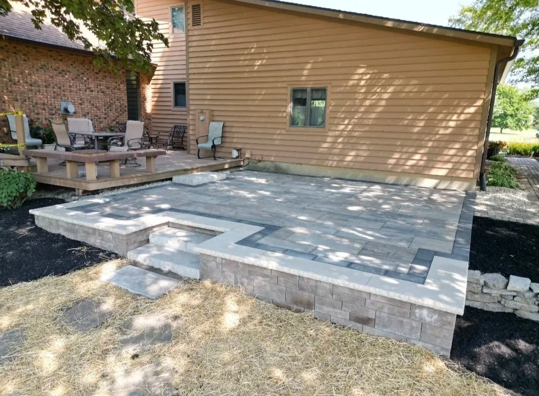 Paver patio with a staircase near a deck