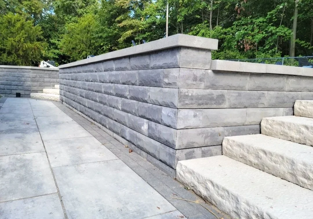 Paver patio with a retaining wall and a staircase