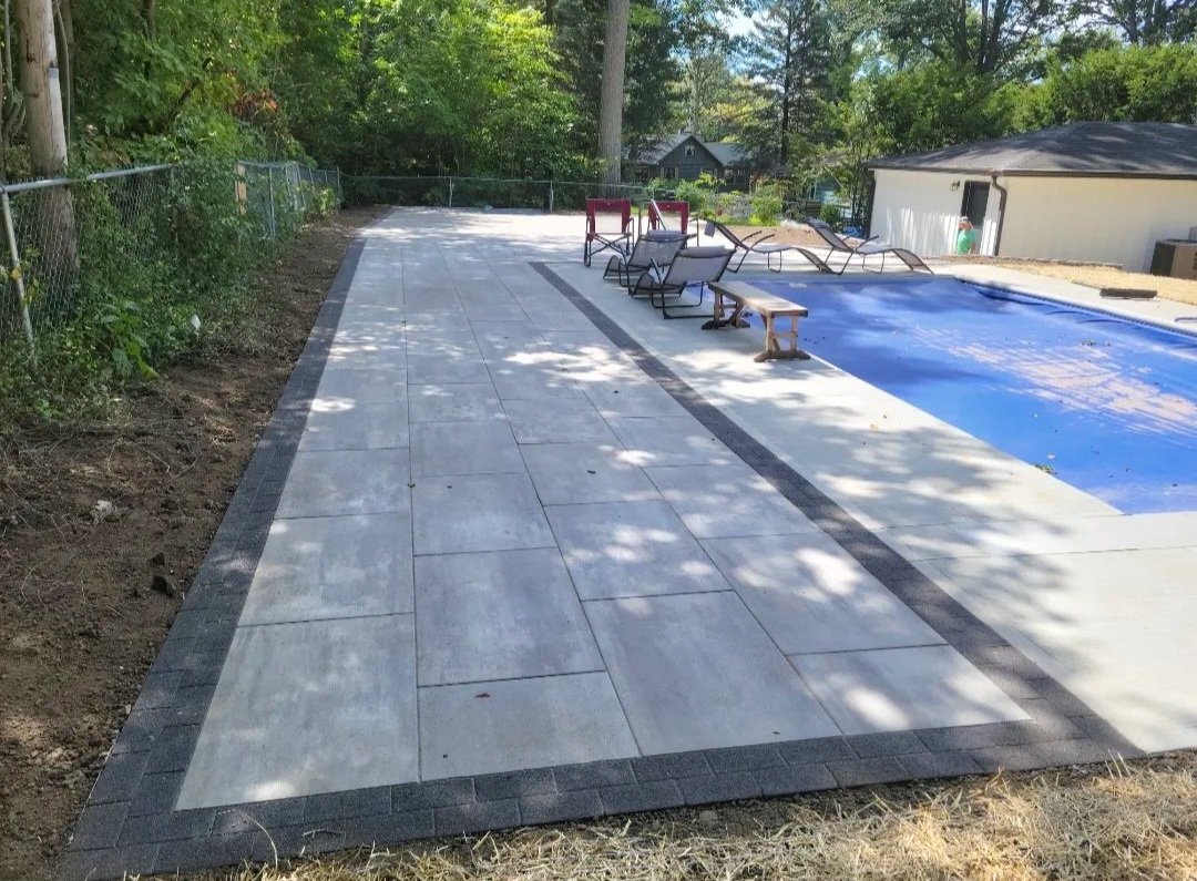Paver patio near a pool and a house