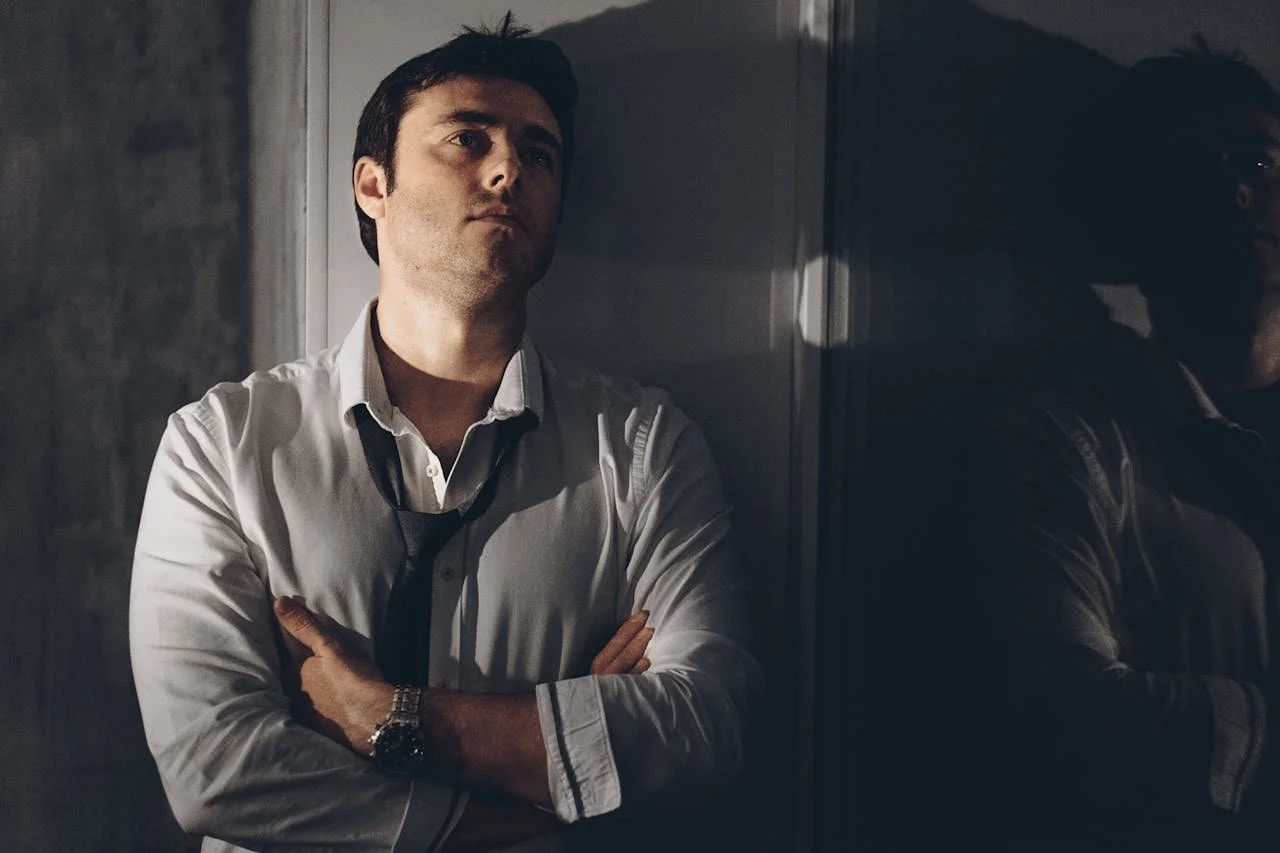 man-thinking-while-leaning-on-white-door
