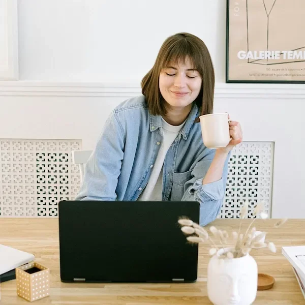 woman at desk smiling at laptop