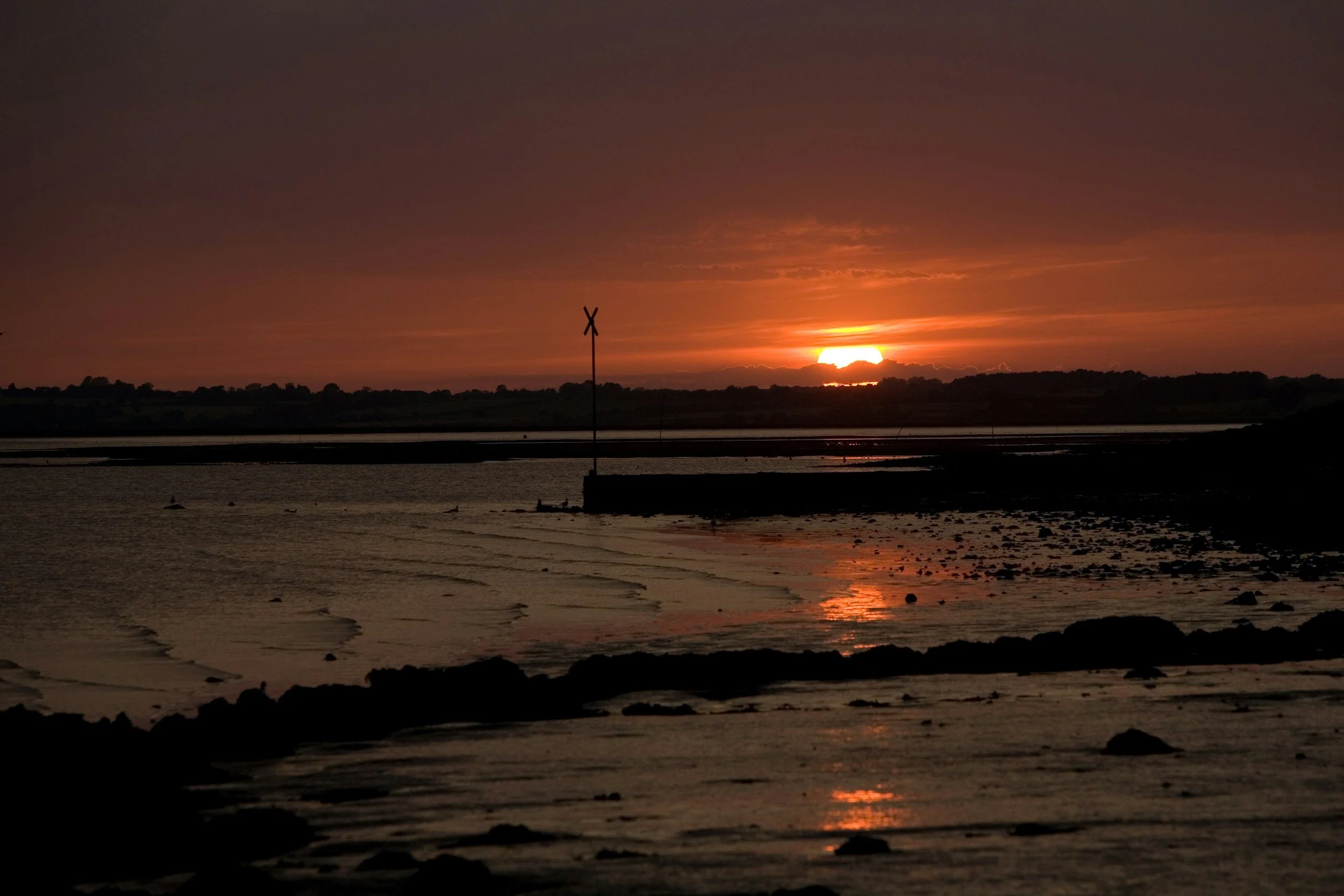 Orange sunset glowing over a rocky coastline