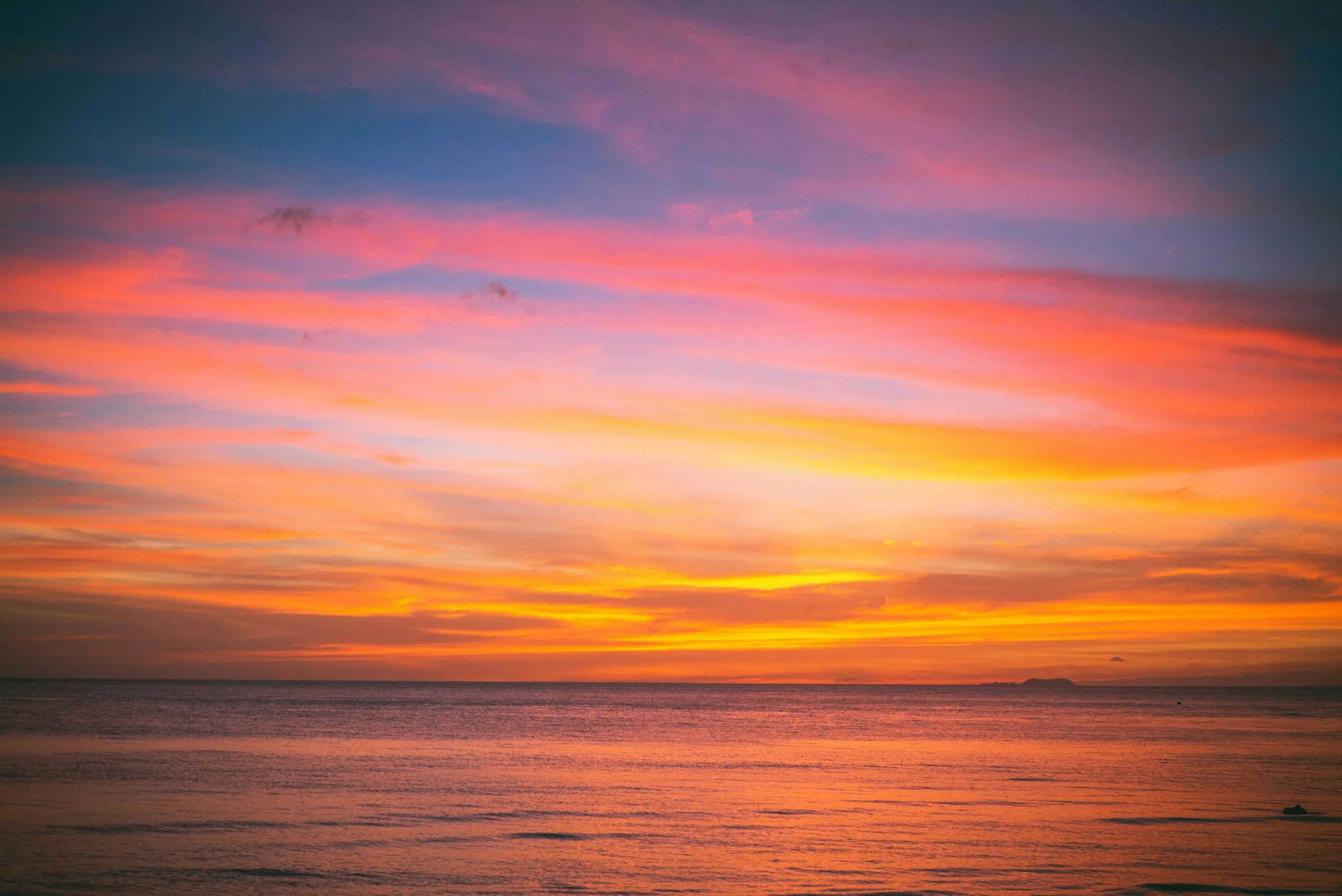 Pink and gold clouds over the sea at sunset