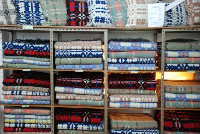 Folded Welsh blankets stacked in soft natural colours