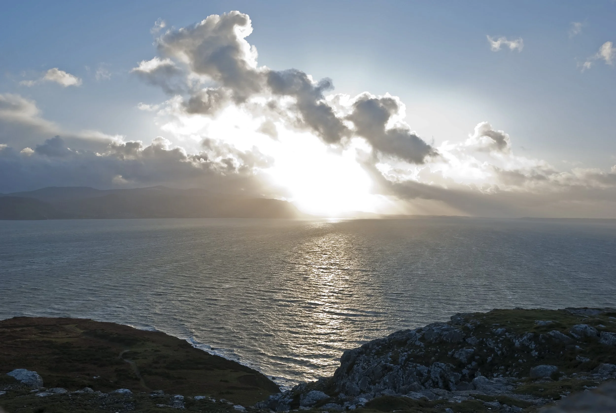 Sun breaking through clouds over the sea from the Great Orme in Llandudno