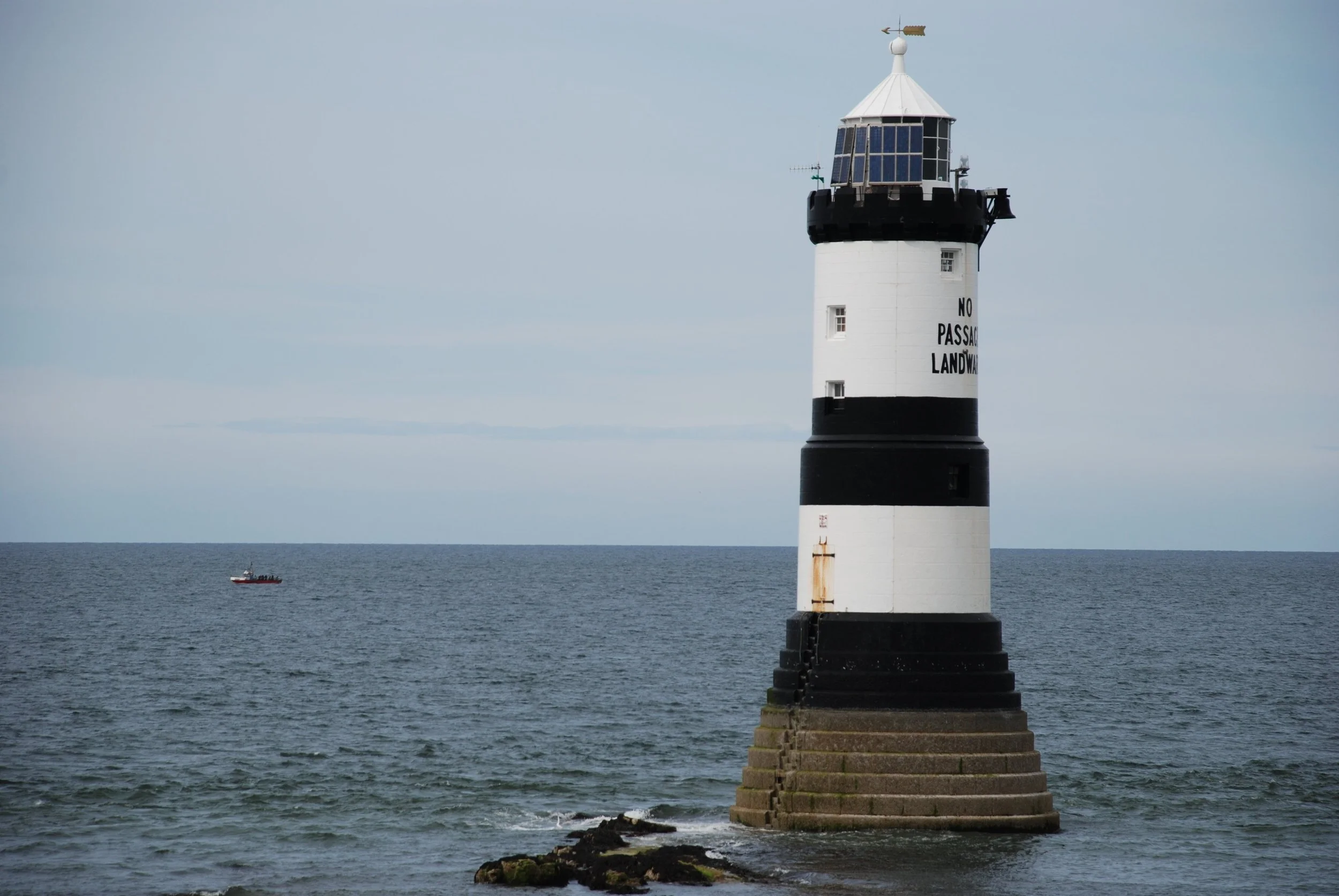 The black and white striped Trwyn Du lighthouse standing in the sea off Penmon