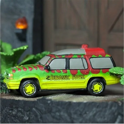 Toy Jurassic Park-themed vehicle with green, yellow, and red colors, featuring the Jurassic Park logo on the side.