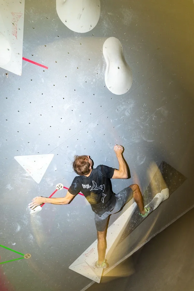 Mann klettert an einer Indoor-Kletterwand