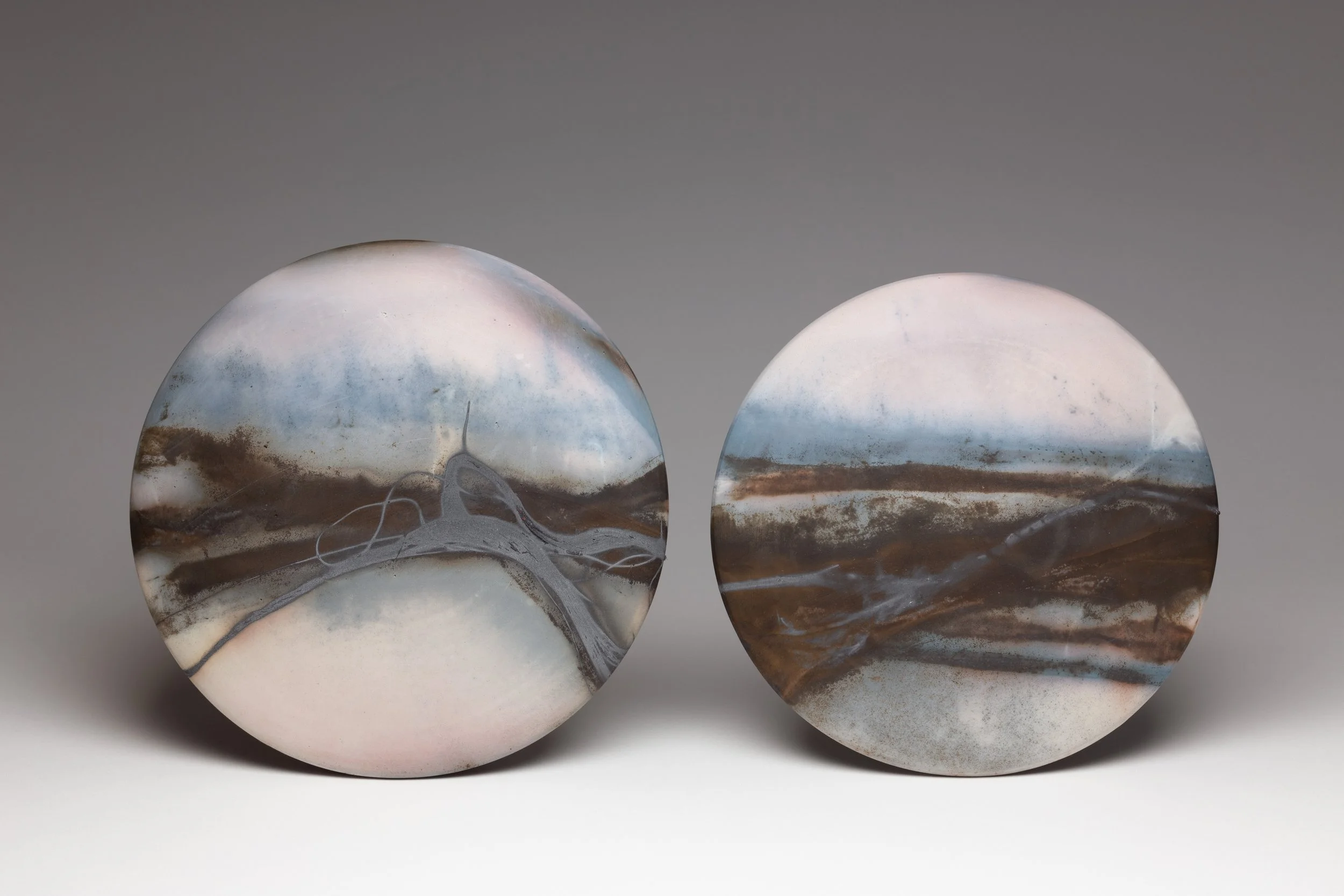 ´Twilight Road´ 2018 Set of 2 Midi Discs
White Stoneware Clay, Thrown & Saggar Fired with West Cork sawdust, seaweeds, recycled wires & oxides 
(H) x (L) x (W) 
19 cm x 19 cm x 2 cm, 18 cm x 18 cm x 2 cm