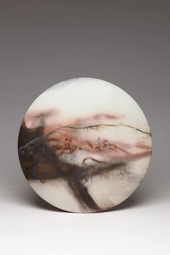 A round piece decorative wall art with abstract pink, brown, black, and white veining and patterns.