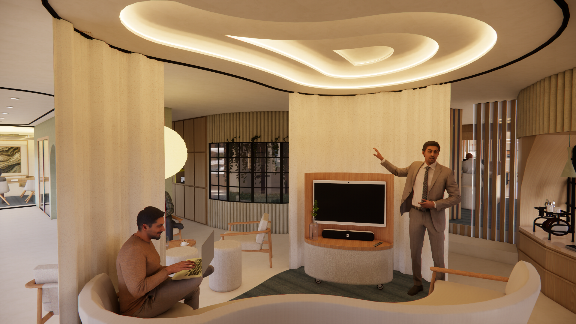 A man in a suit giving a presentation in a modern living room while another person uses a laptop nearby.