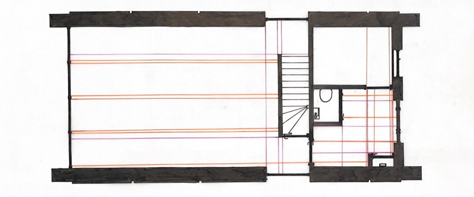 Floor plan of a building including stairs, bathroom, and multiple rooms with structural lines.