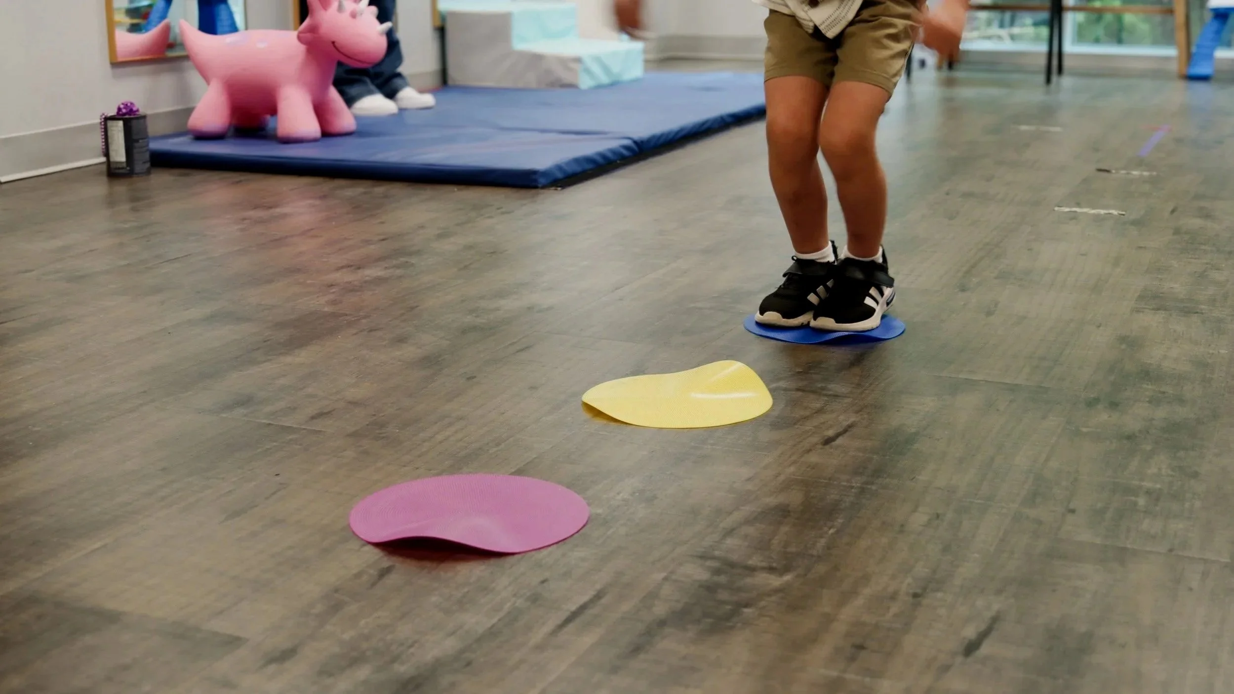 A young child jumps as part of a gross motor development evaluation at the Looking Ahead Pediatric Therapies office. 