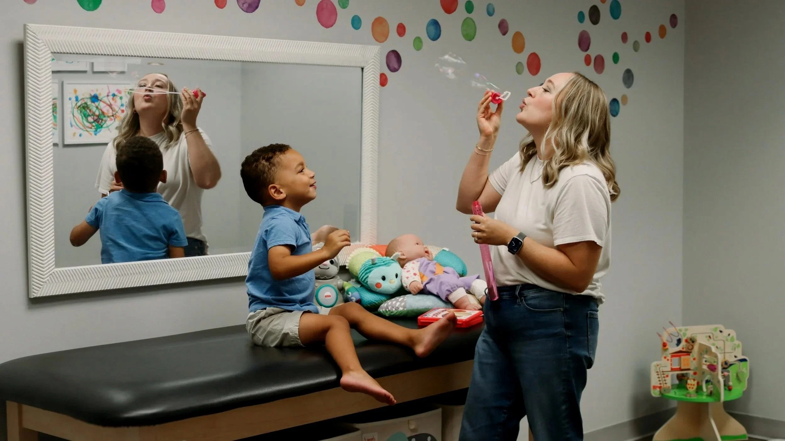 A speech and feeding therapist at Looking Ahead blows bubbles with a pediatric therapy patient. 