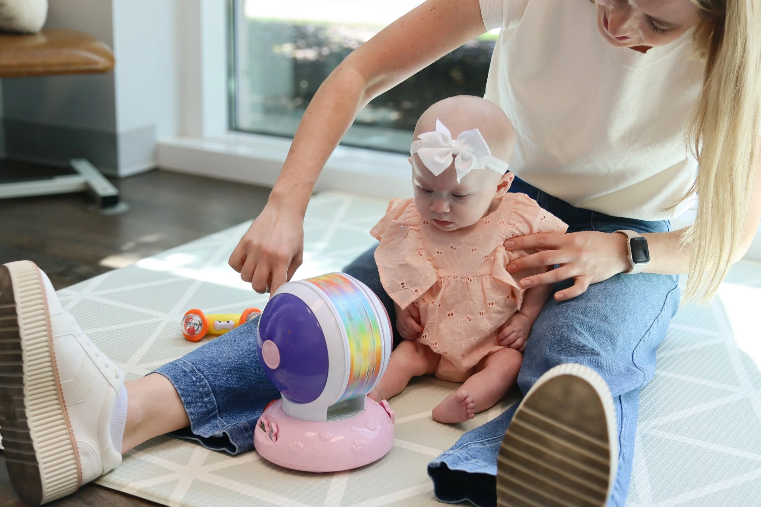 A Looking Ahead therapist sits with an infant who is working on holding her head up and improving her range of motion. 