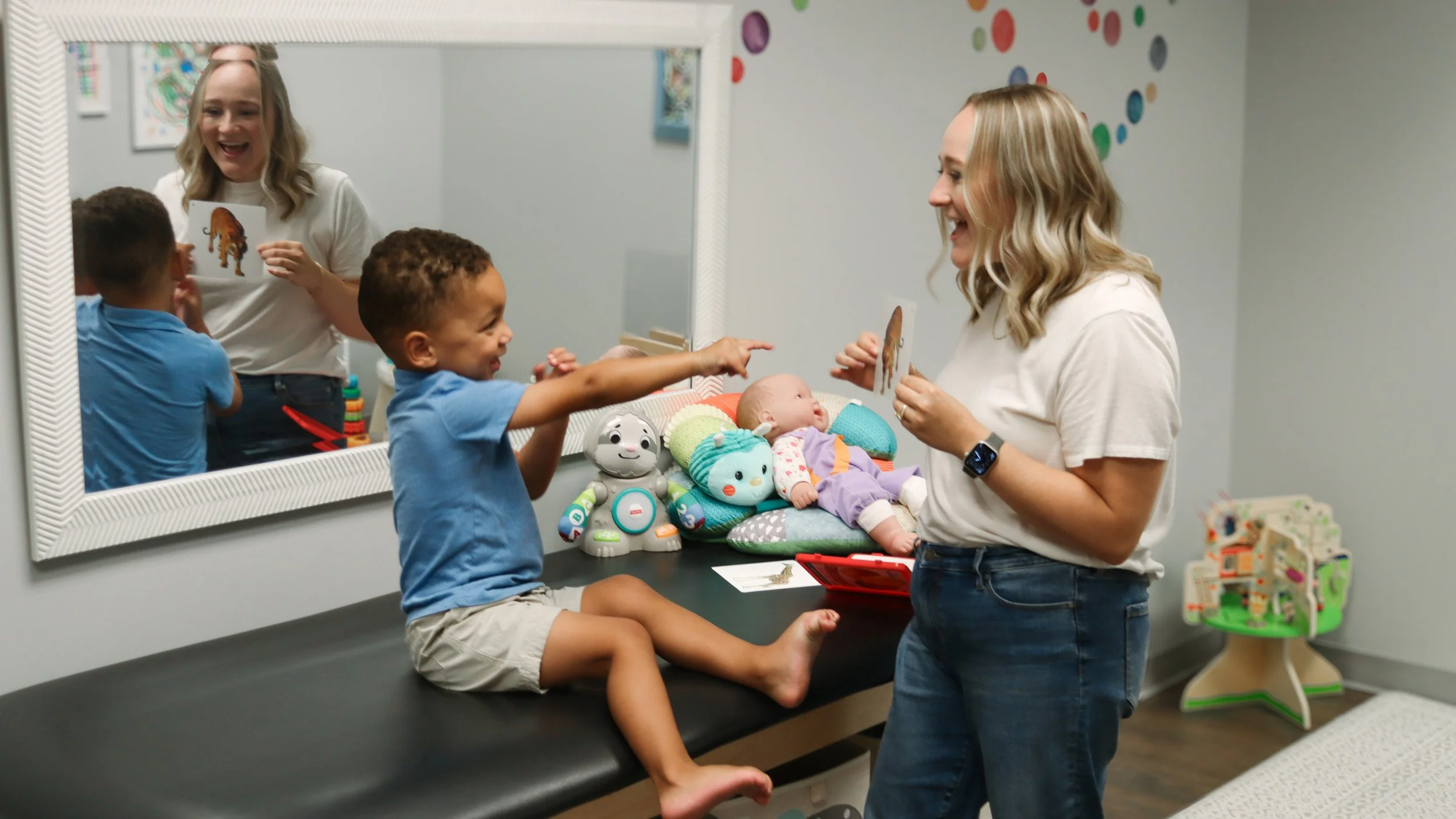 Speech therapist Kayla Mathai shows flashcards to a child as part of his speech therapy work