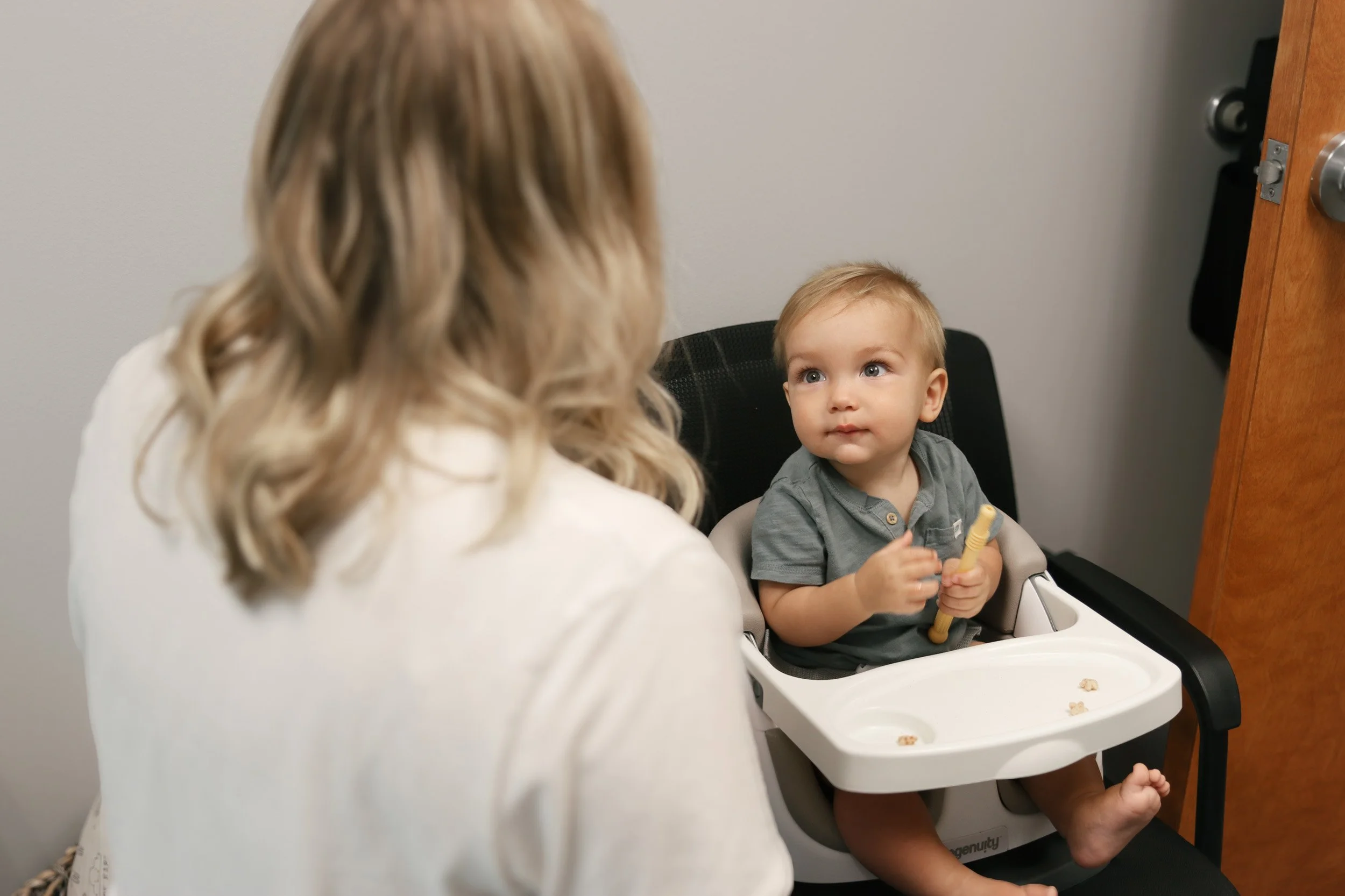 A child sits independently in a high chair working on feeding therapy skills with a specialized feeding therapist from Looking Ahead Pedatric Therapies