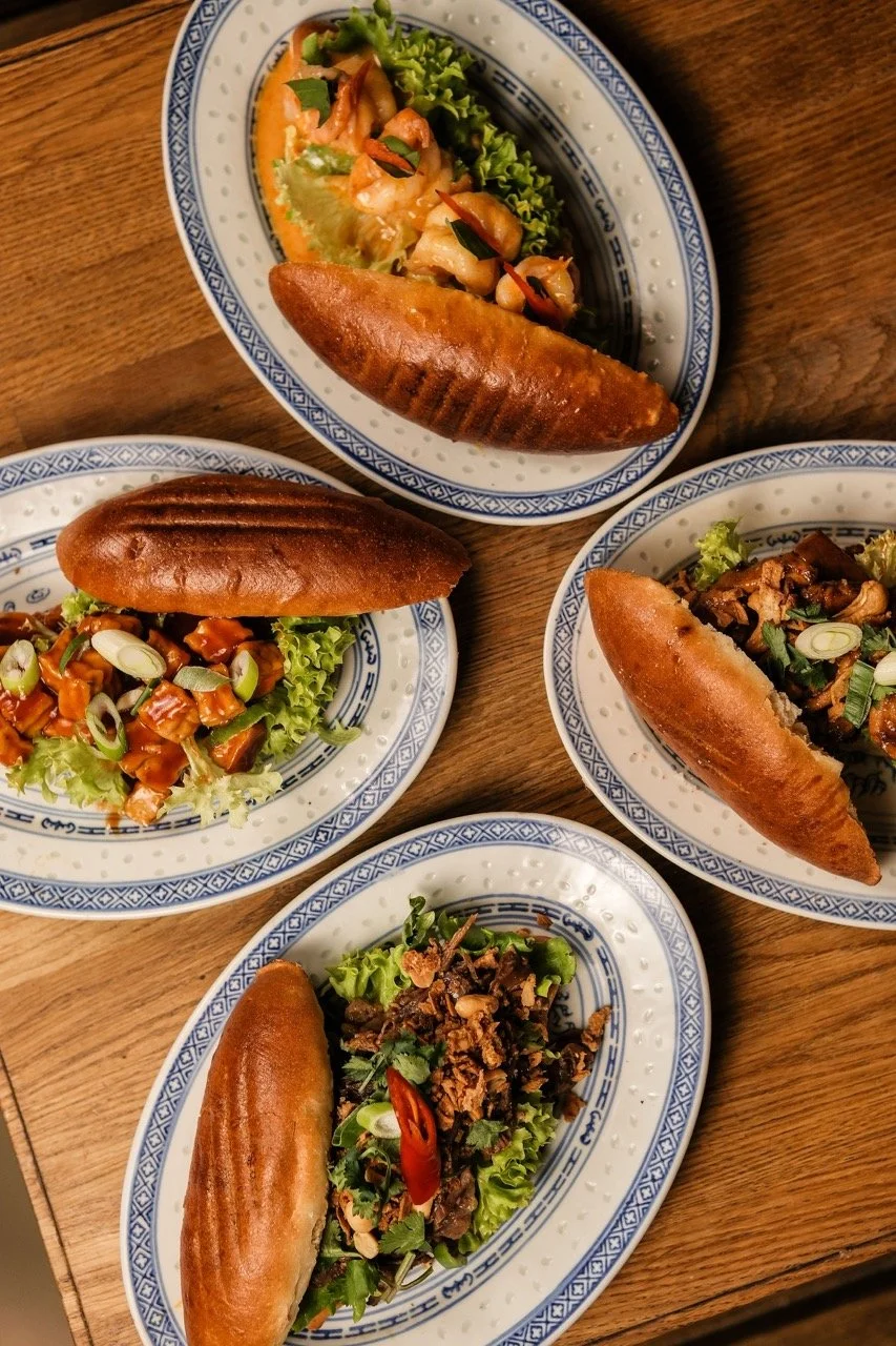 Bowl of shrimp and vegetable stir-fry over rice, garnished with chili and cilantro, placed on a wooden table.