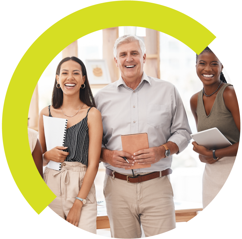 Three diverse smiling professionals in an office, holding notebooks and tablets.