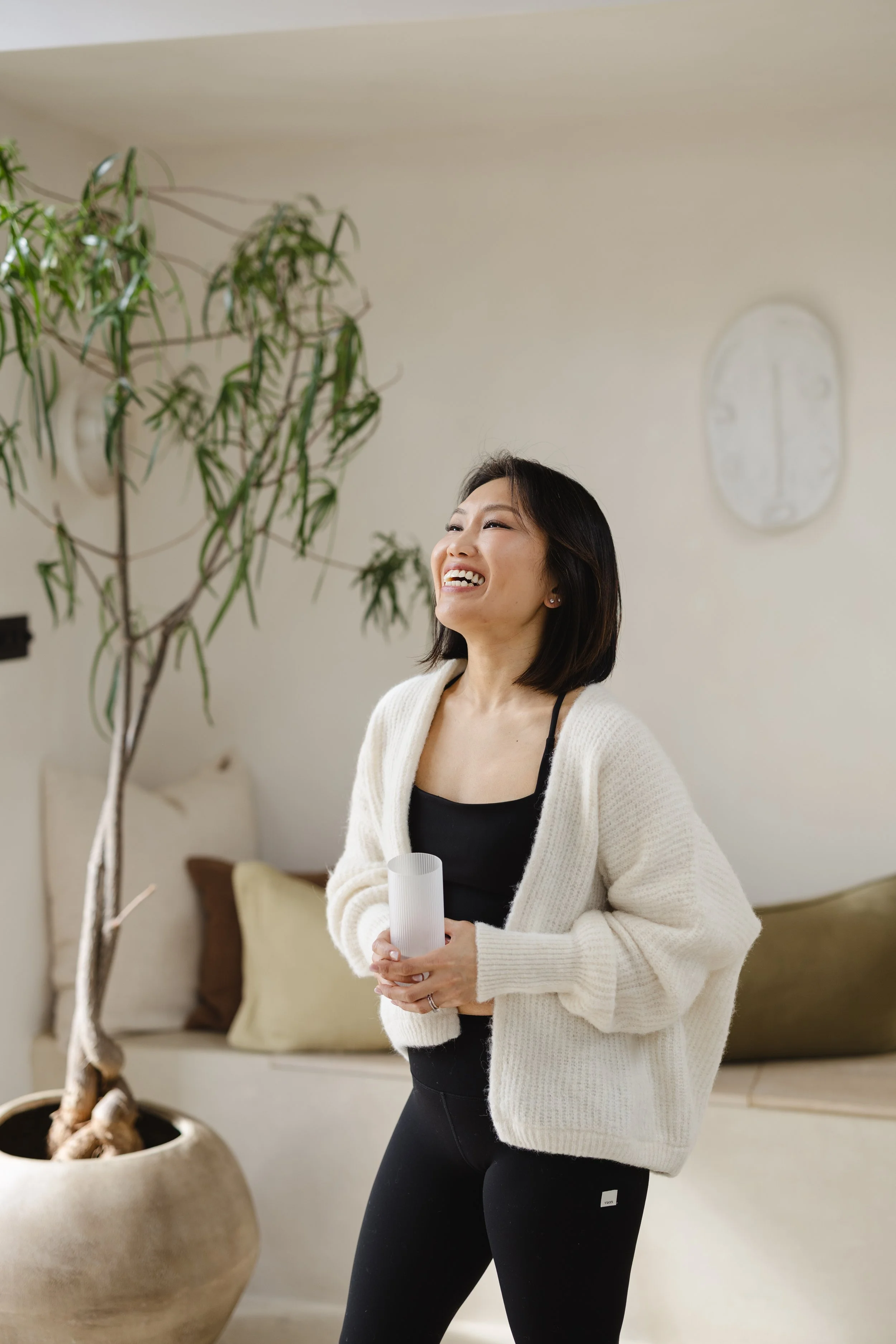 Beautiful Japanese woman. ligth airy room, palm in workout gear, ready to teach a Pilates class