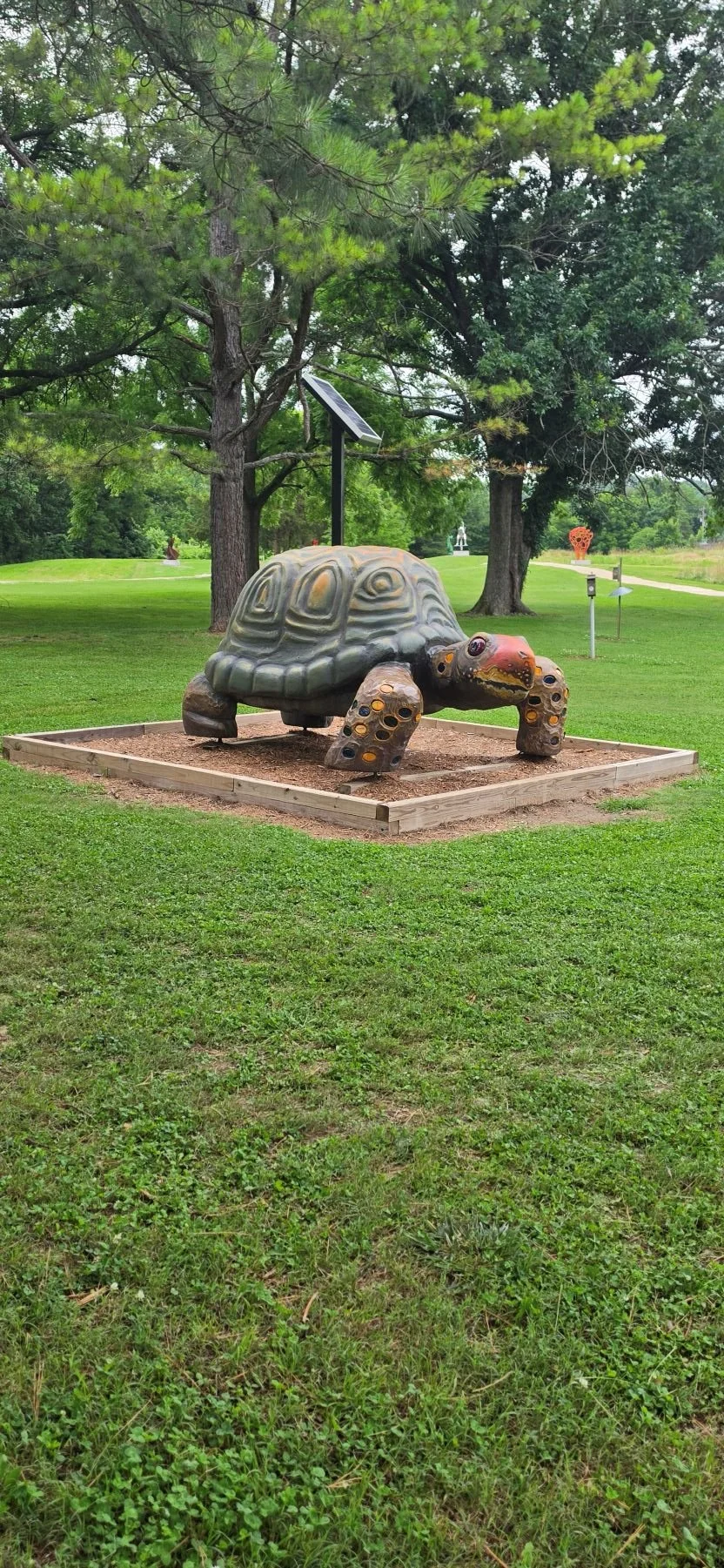 A picture of a giant turtle that is found along the Blue bird trail in Bella Vista