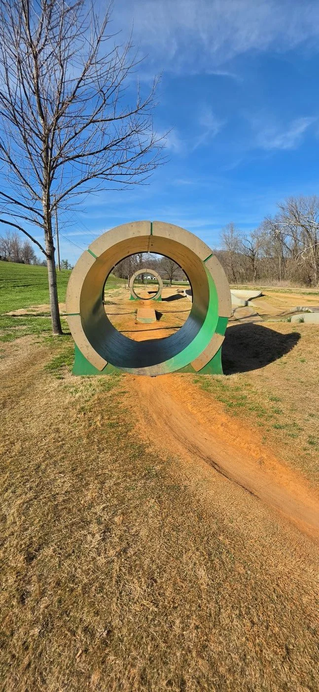 The Bike Playground's concrete berm that is a feature at the small bike park devoted to really young riders. The feature in the picture looks like a giant water pipe used by the City to transport water underground throughout the city.
