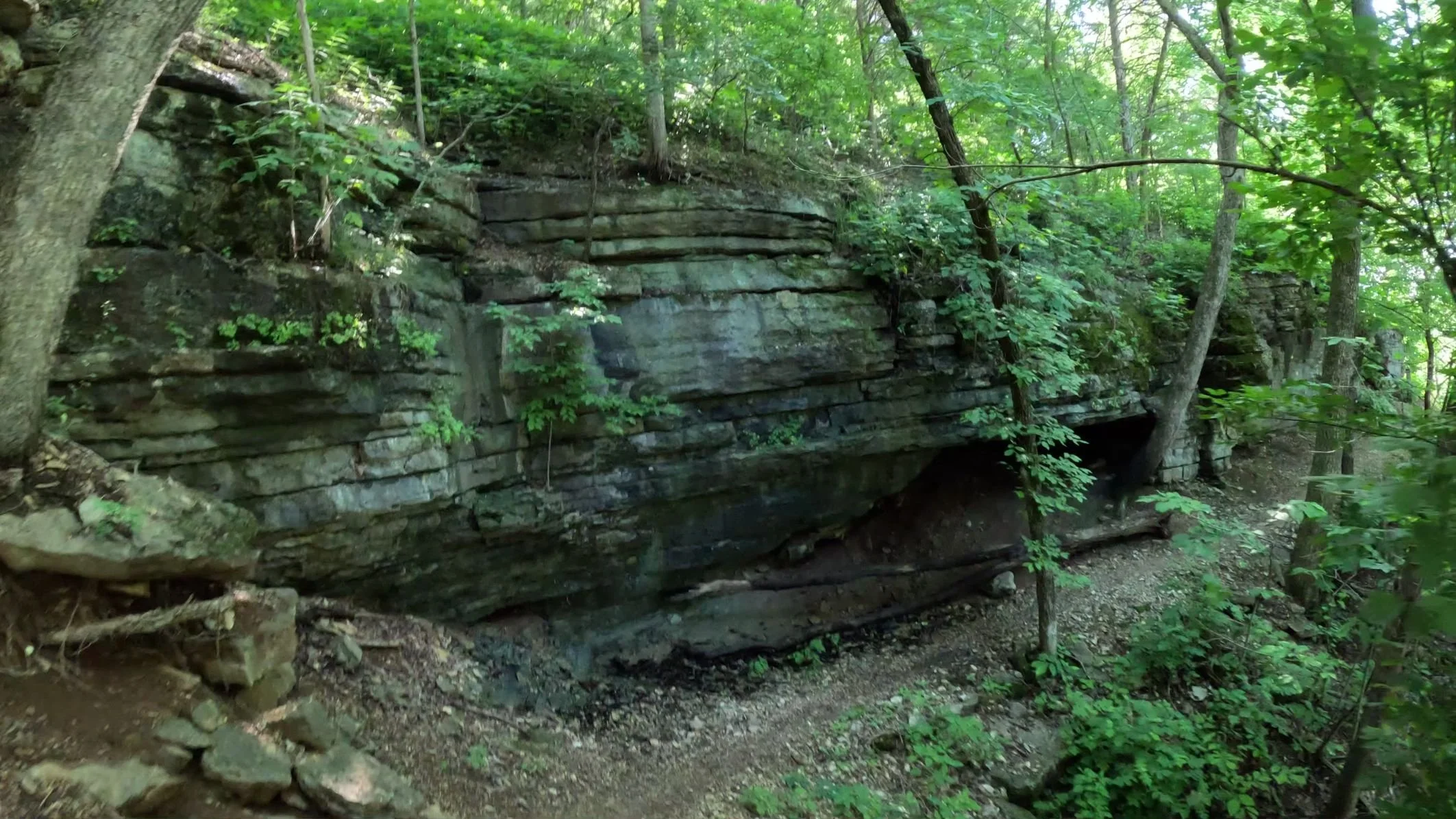 The Sally Singletrack trail runs along the bottom of a rocky Arkansas rock bluff