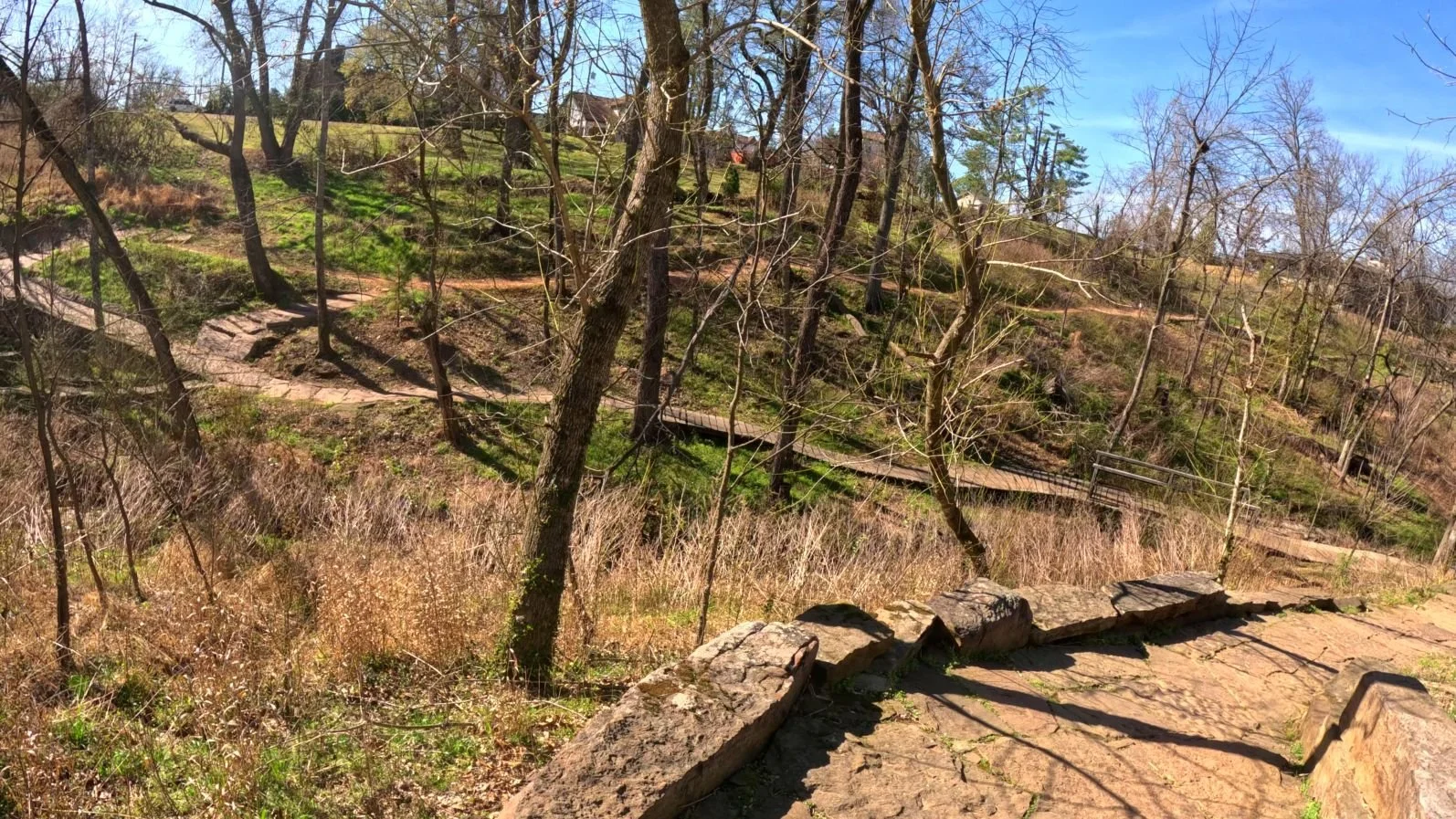 A view of the mountain bike trail through Compton Gardens. You can see the wooden bridge over the creek and the rock plated berms that make up the trail