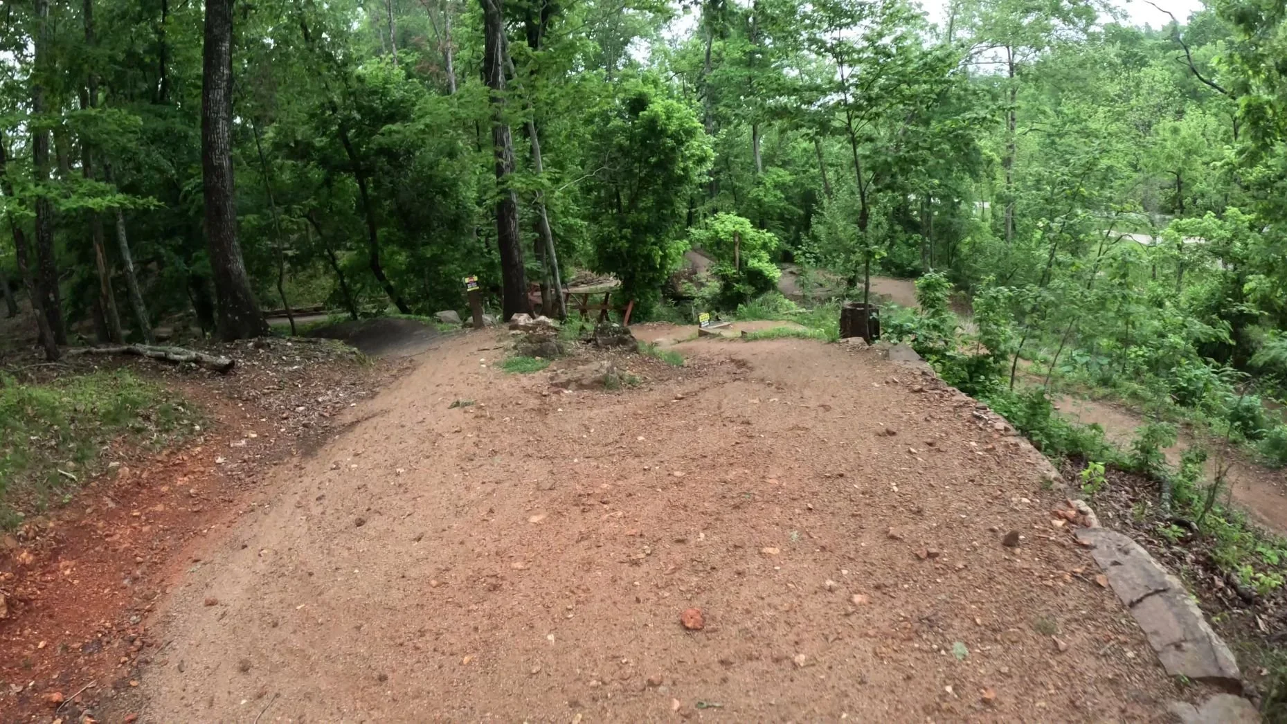 An image of the end of the trail as several trails merge before a wooden bridge near the Highway to Heaven Trail in Bentonville's Slaughter Pen Trail System.