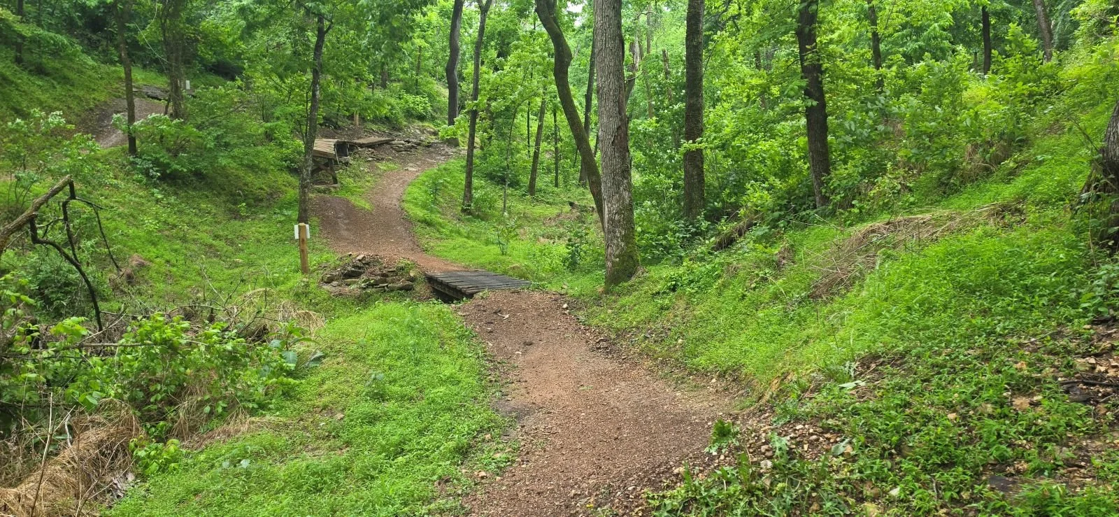 A macro view of the Berm Creek trail showing the drop from the ramp and the jump or bridge across the creek