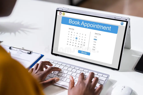 Person booking an appointment on a computer screen showing a calendar and time slots.