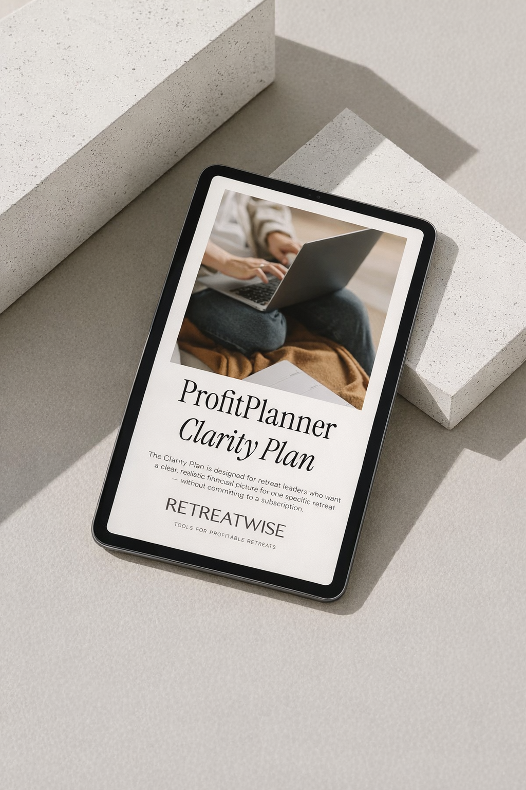 A digital tablet displaying a ProfitPlanner Clarity Plan for retreat leaders, placed on textured white blocks in natural lighting.