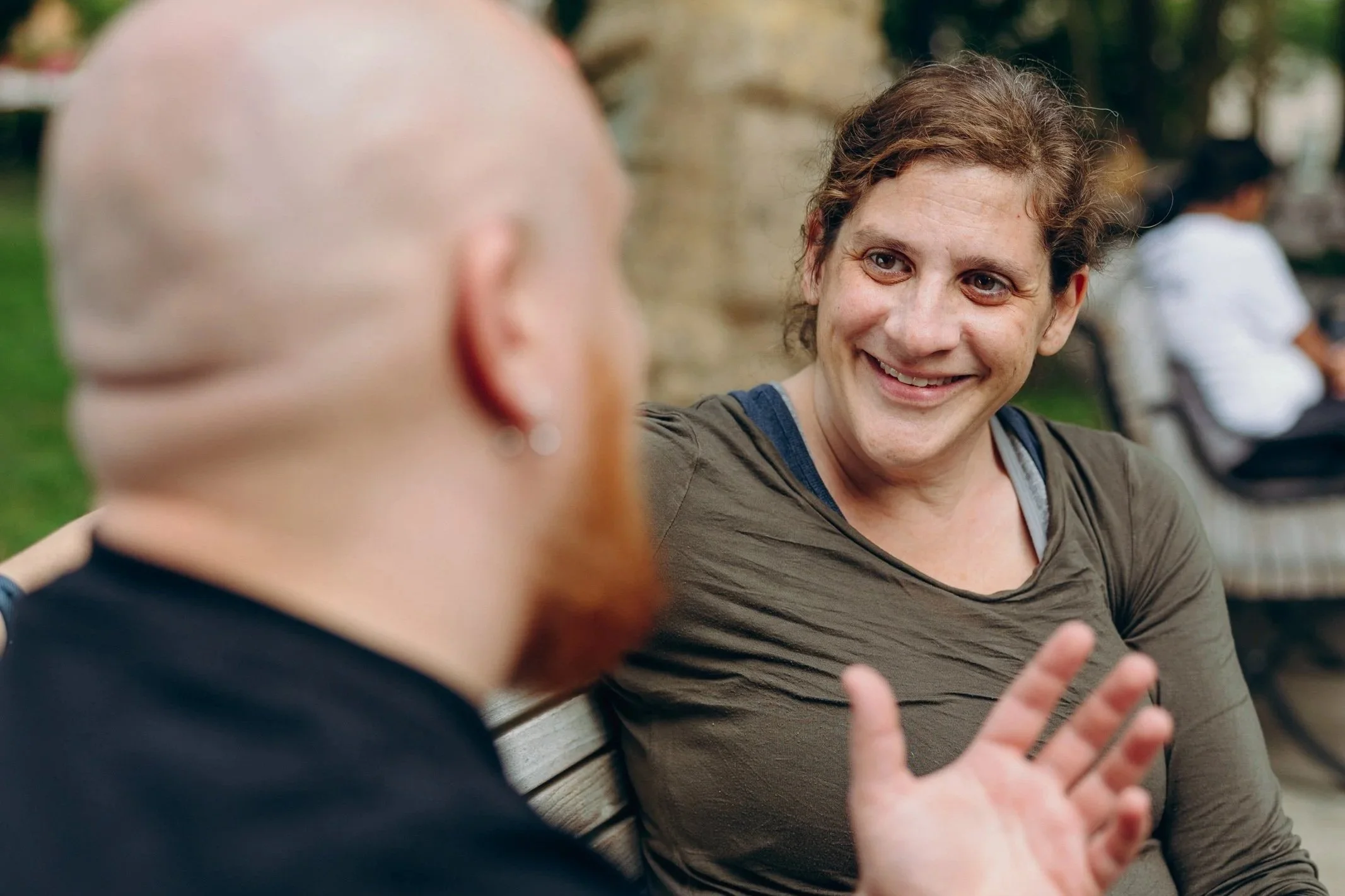Danna talking to another on a park bench