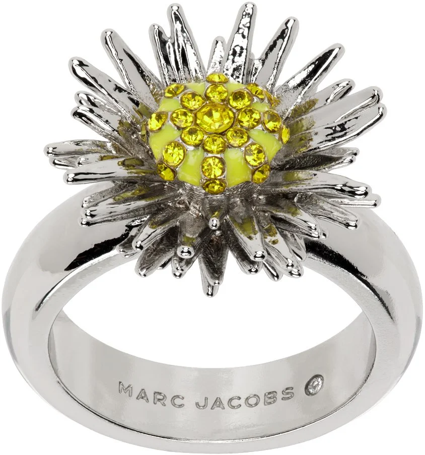 Silver ring with a flower design featuring yellow gemstones in the center.