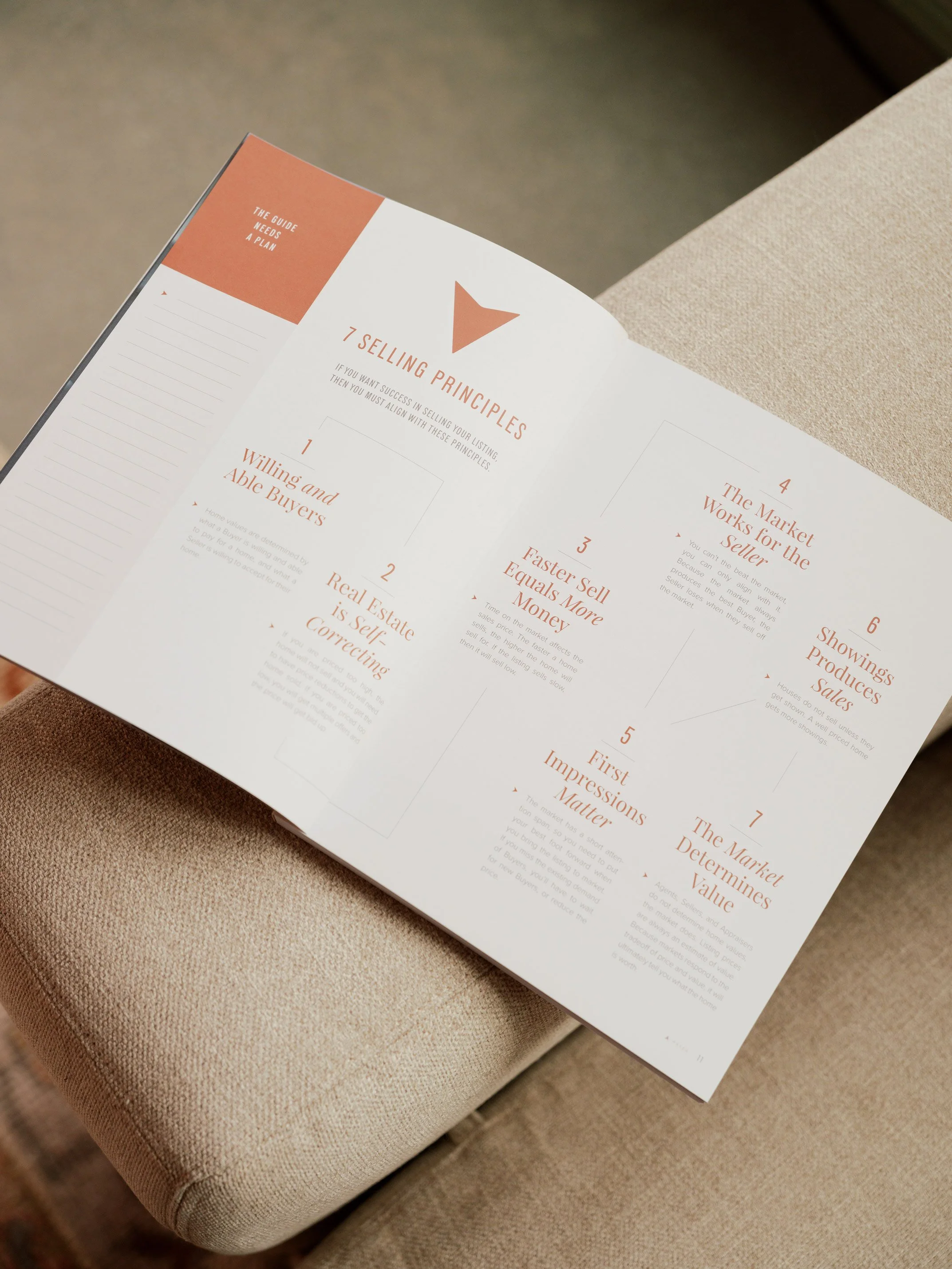 Open page of a booklet showing '7 Selling Principles' with text and numbered points, placed on beige fabric surface.