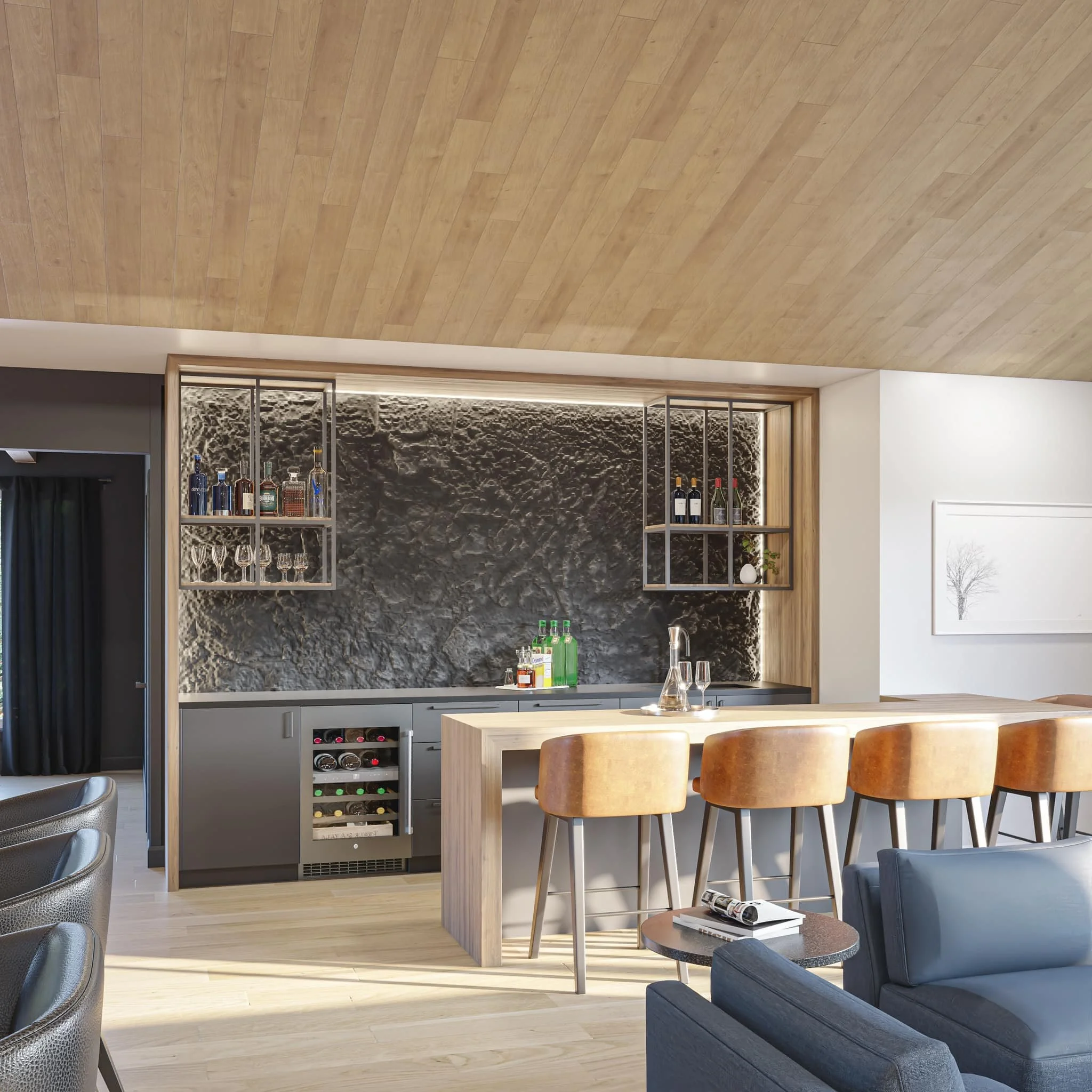 Modern kitchen with black textured backsplash, gray cabinets, wooden bar counter with four tan chairs, and a small round table with a magazine, in a living space with wood and white walls.