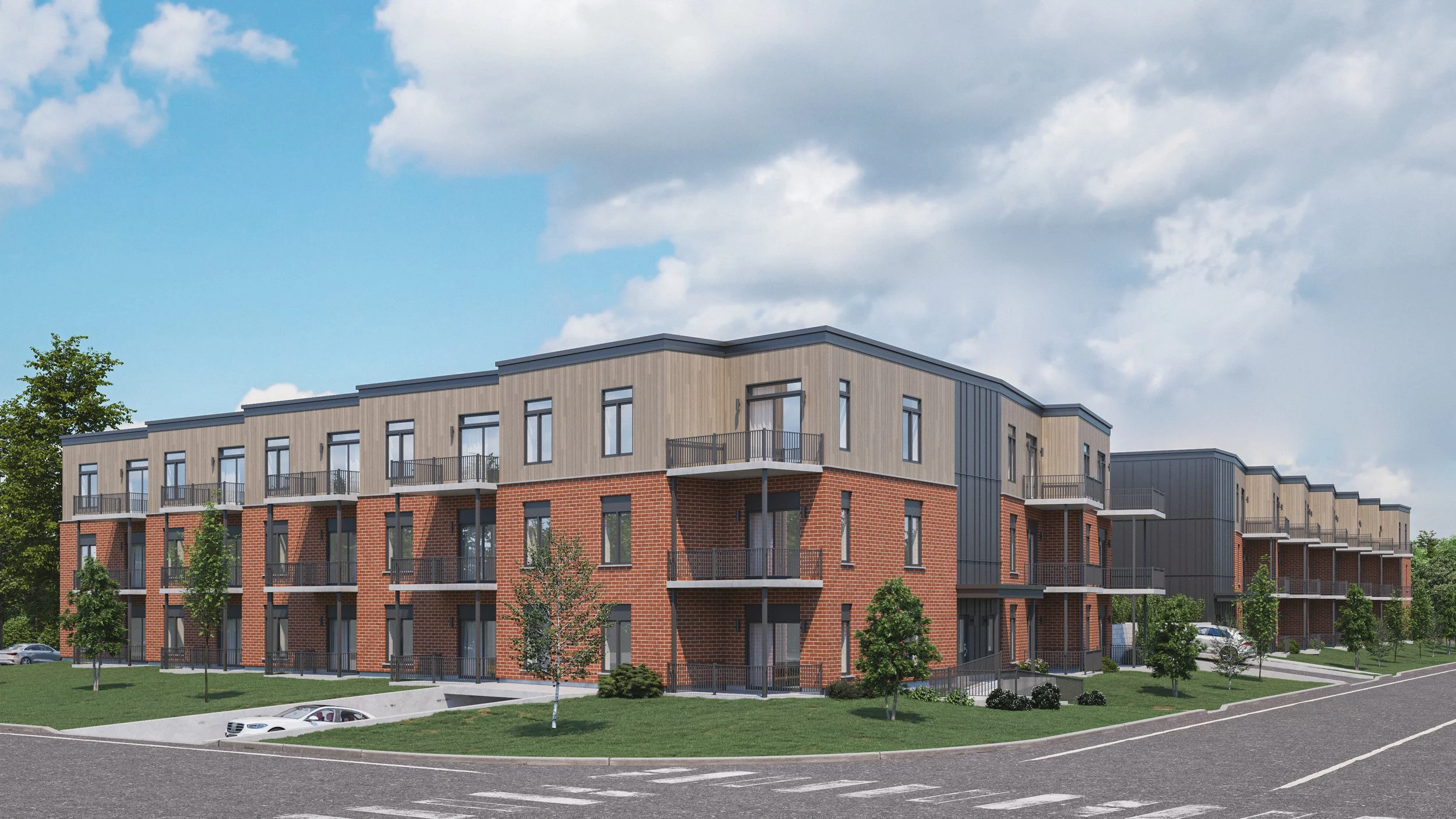 Three-story modern apartment building with brick and wood facade, small balconies, and surrounded by green grass, trees, and parking lot, under partly cloudy sky.