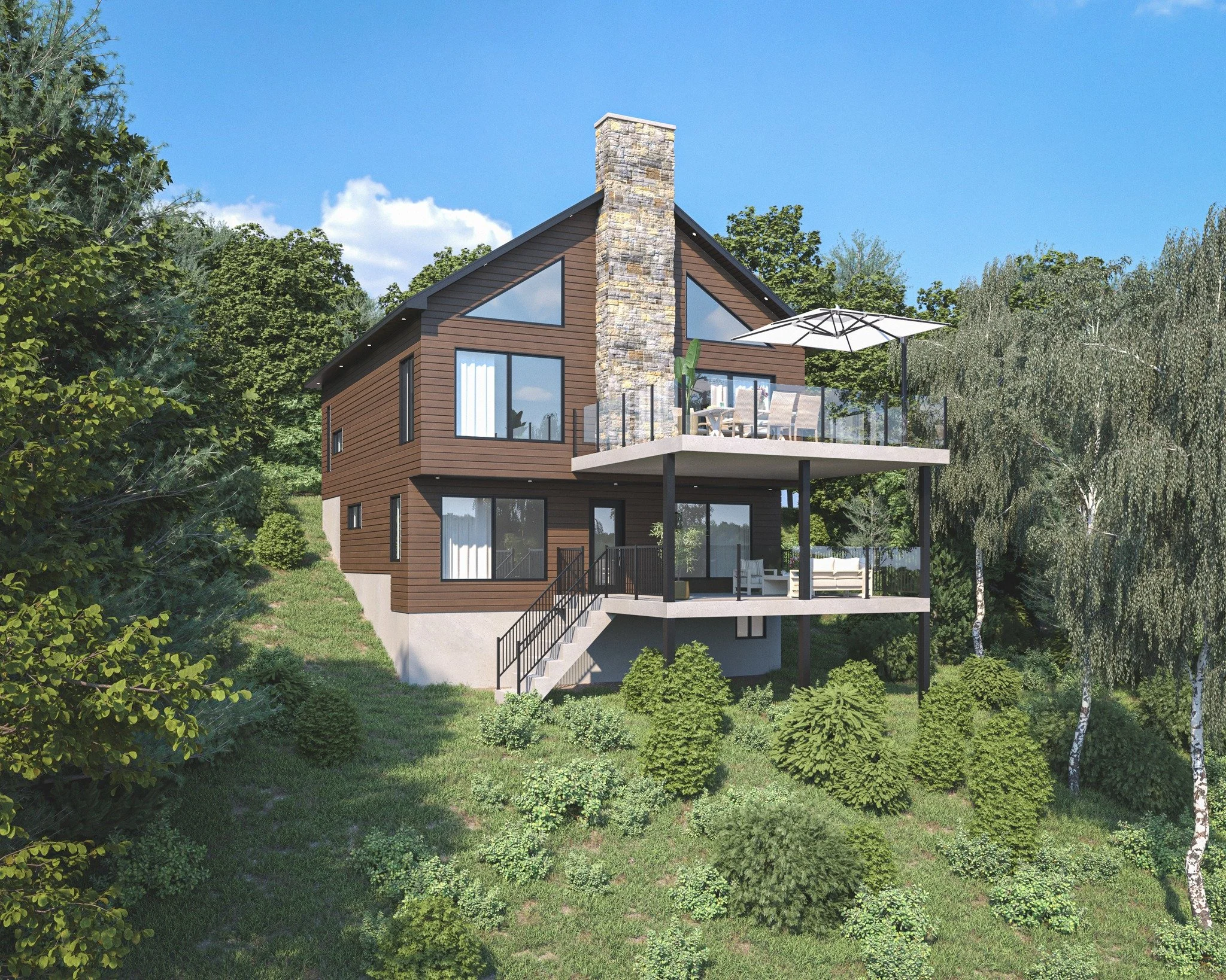 A modern multi-story house with brown siding and large windows, built on a slope with a concrete staircase leading to an upper deck. The house has a stone chimney and two balconies with outdoor seating, an umbrella, and glass railings. The surroundings are lush with green trees and shrubs under a bright blue sky.
