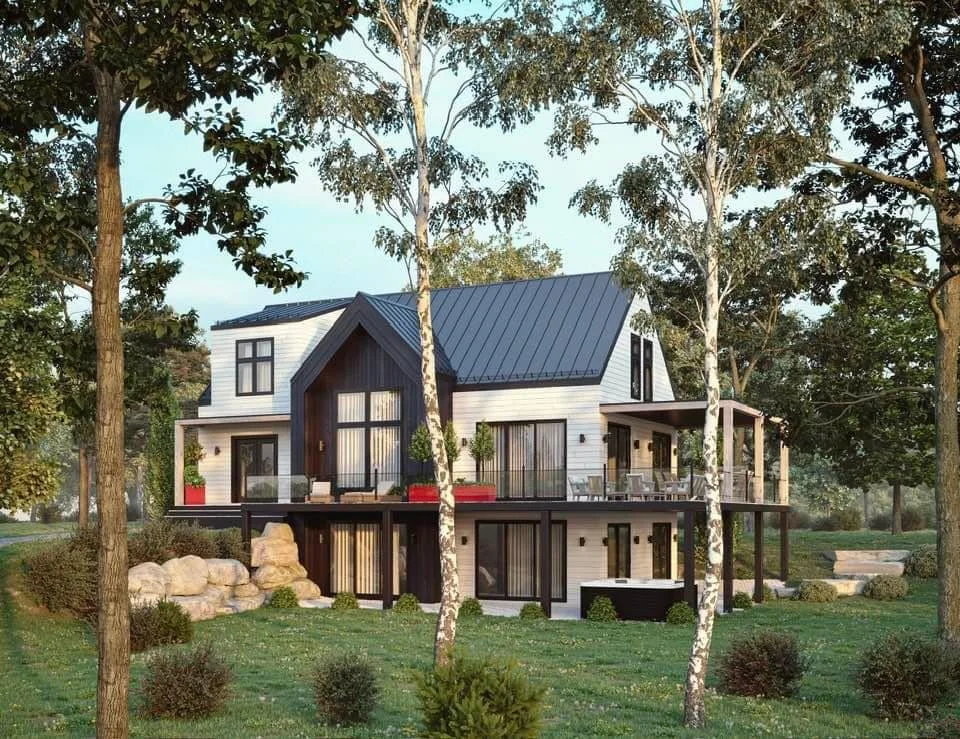 A modern two-story house with a dark roof and white siding, surrounded by trees and greenery.
