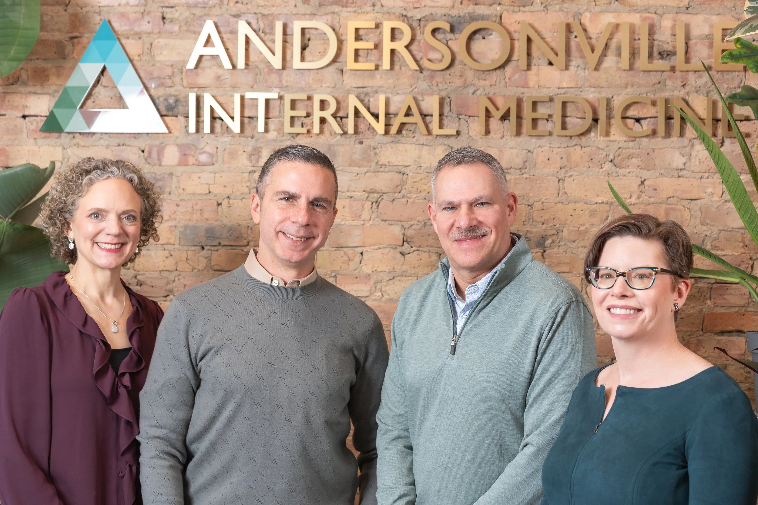 Group of physicians standing in front of a brick wall with 'Andersonville Internal Medicine' sign