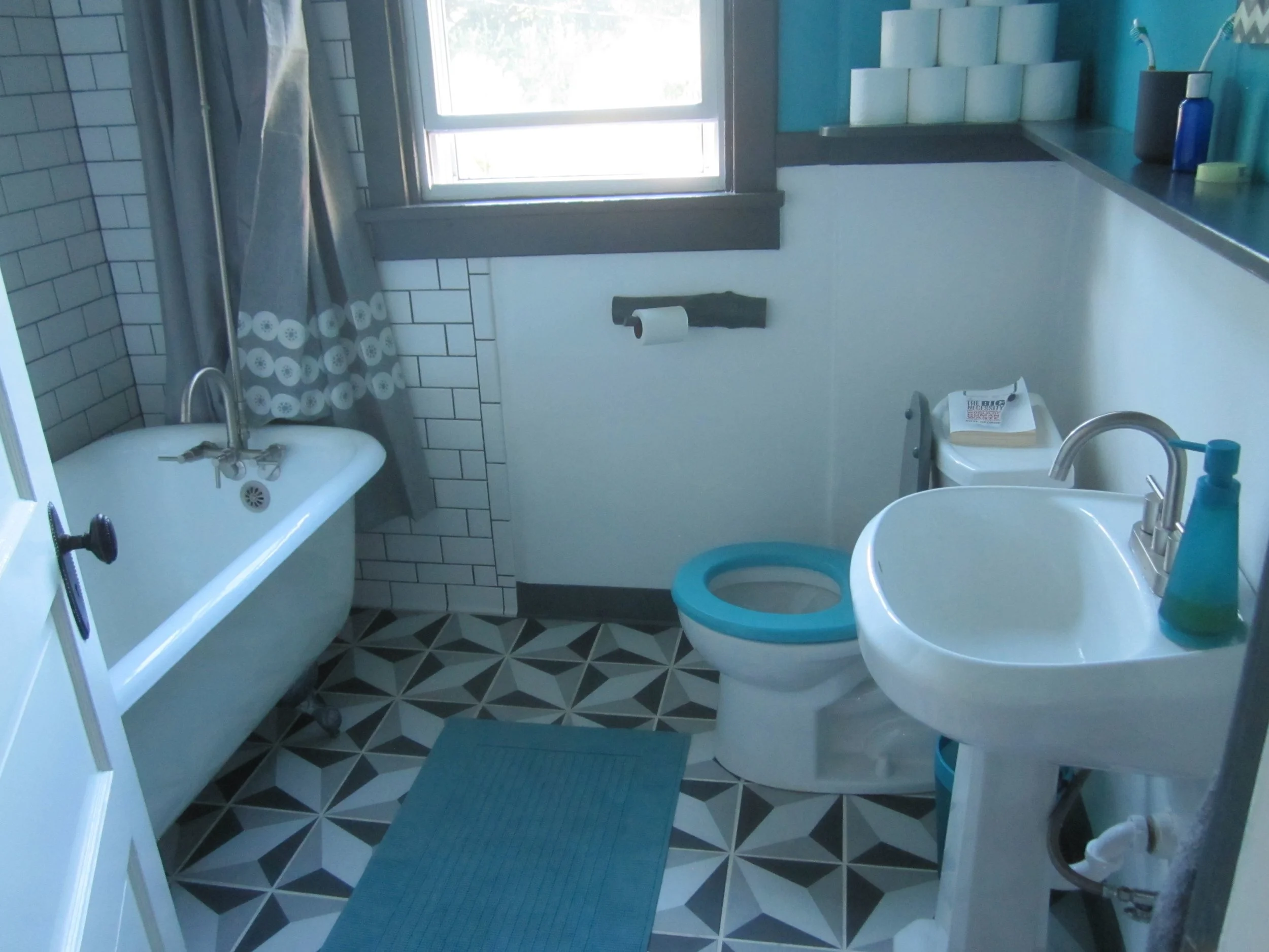 A small bathroom black, white, and teal bathroom with clean lines and organized objects. (Designed by O.E. Zelmanovich. Zoe Zelmanovich. Zoe Mizuho)