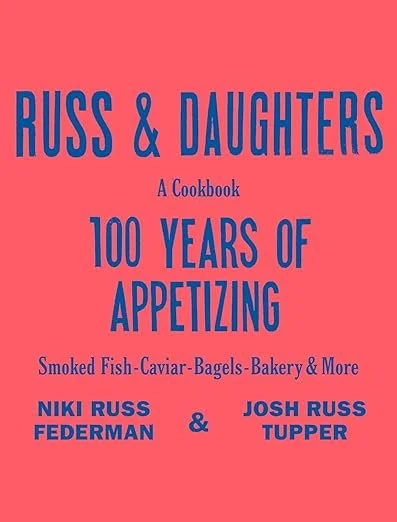 Book cover titled 'Russ & Daughters: A Cookbook 100 Years of Appetizing' featuring smoked fish, caviar, bagels, bakery, and more, by Niki Russ Federman and Josh Russ Tupper.